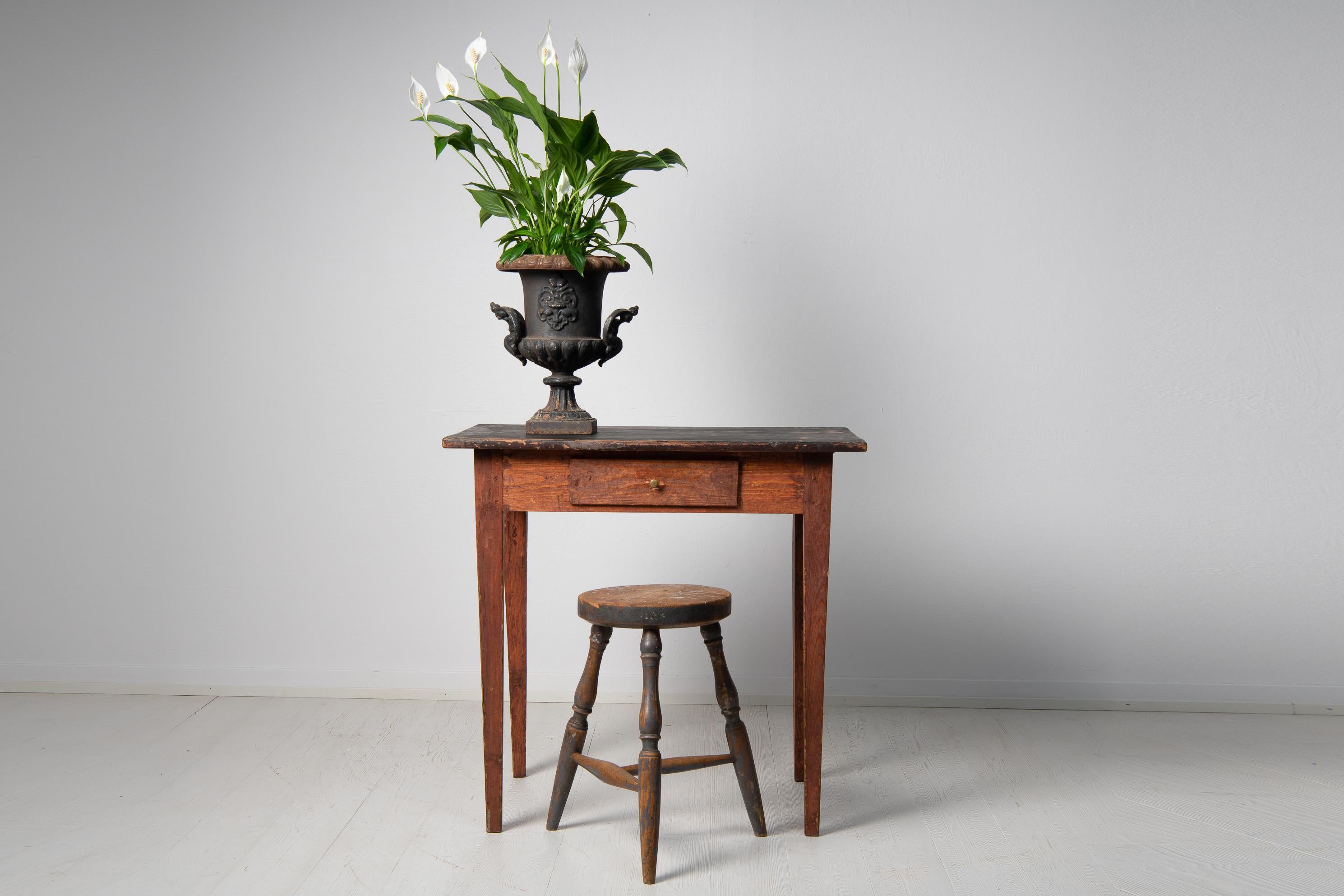 Folk art side table in gustavian style from Sweden, with tapered legs and a drawer. The table is painted pine with traces of the original paint and has the patinated surface only time can make. The drawer has the customary ink stains. Height from