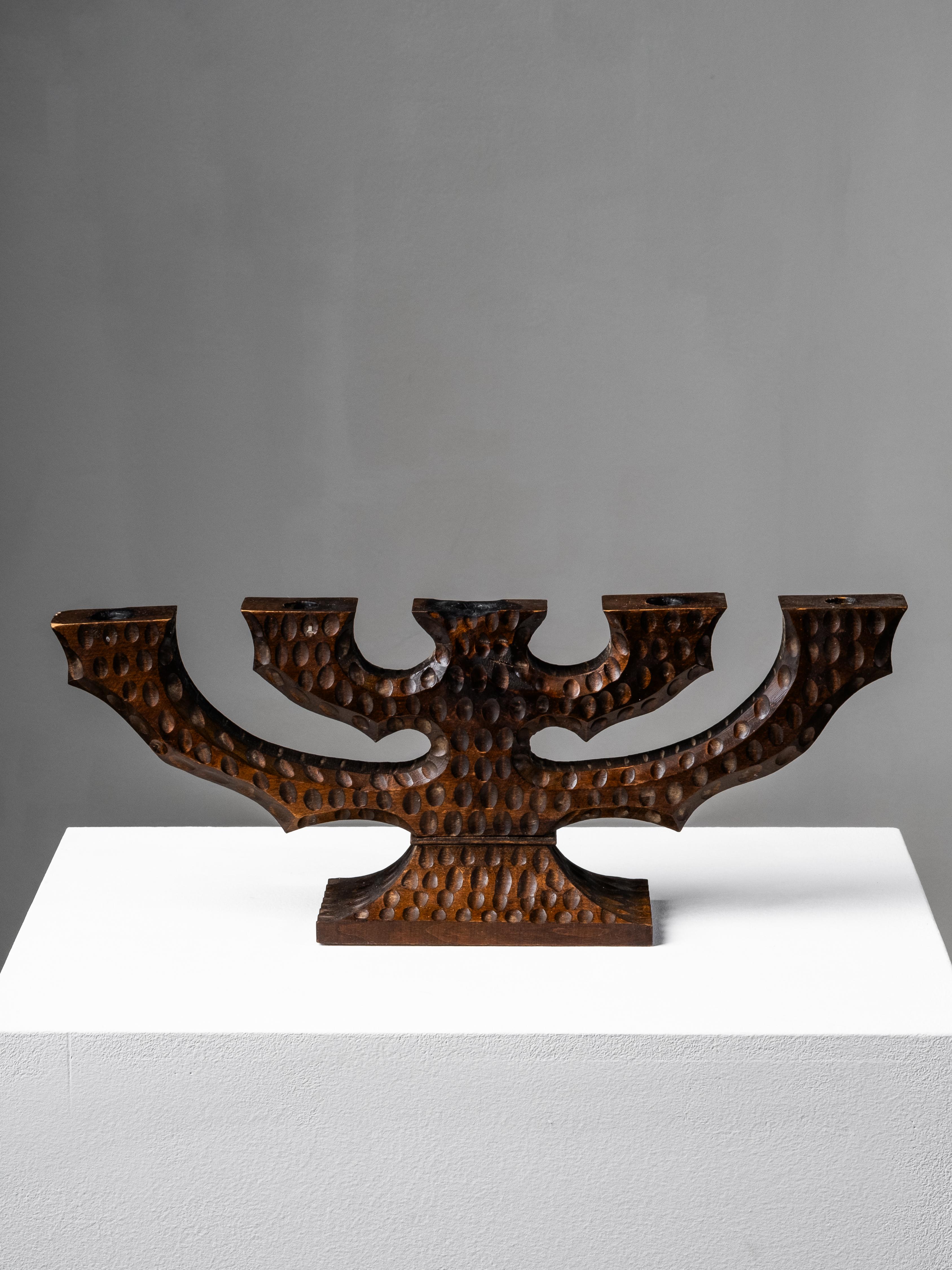 A rare Swedish five-arm candelabra, handmade from solid wood in the 1940s. The design blends folk tradition and modernist sculpture - its bold silhouette and rhythmic surface carving give it an architectural presence. Each arm curves outward in