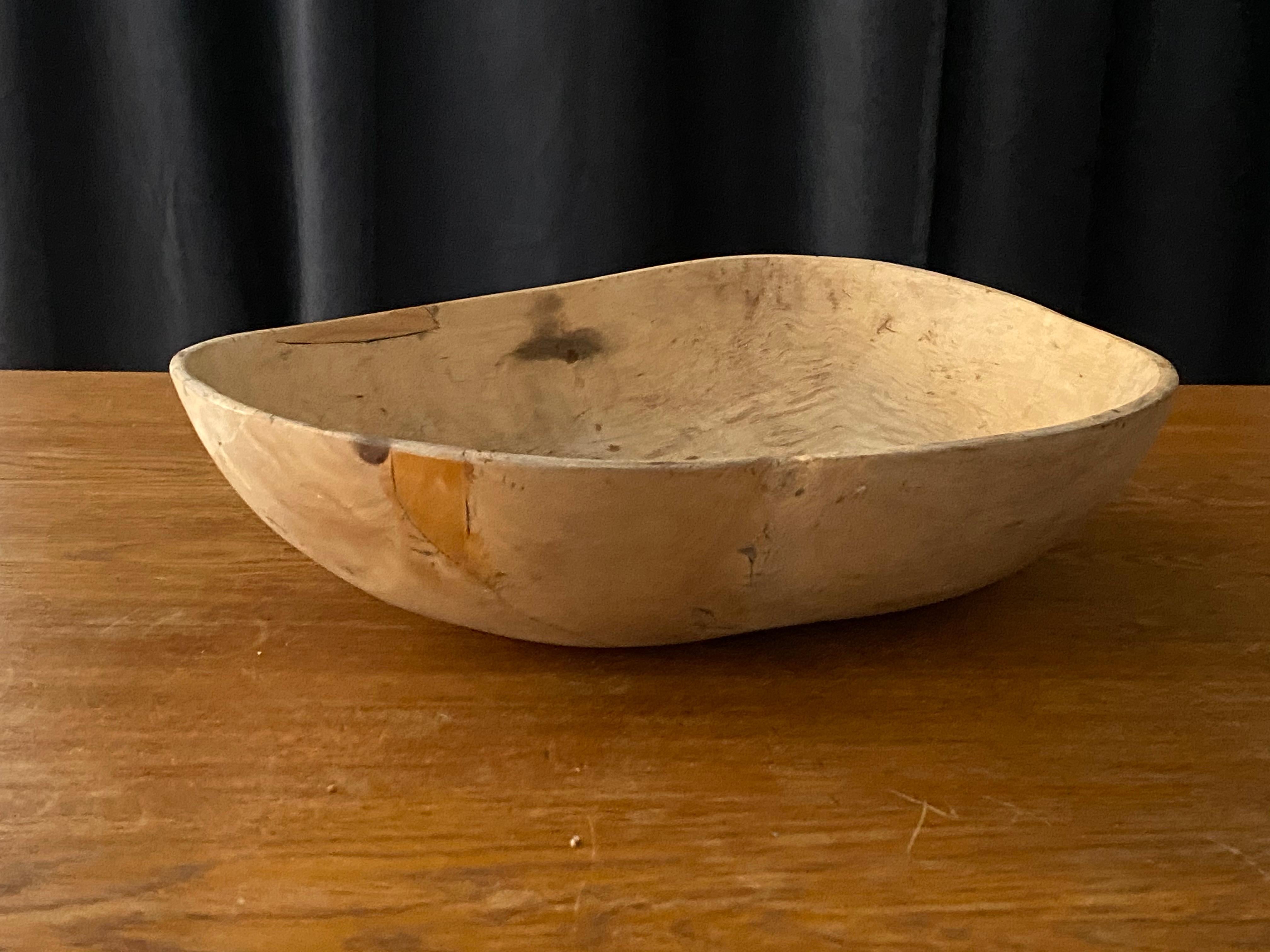 An antique and unique large organic and early farmers wooden bowl. With highly appealing patina, losses, features beautiful old repairs. Produced in Sweden, 19th century. Dated 1822.

 