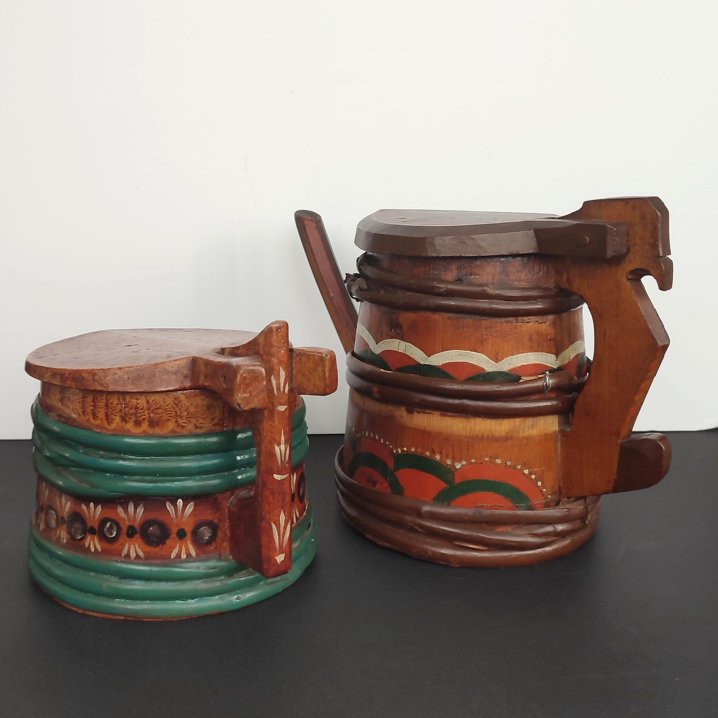 Swedish wooden Lidded Tankard and Pitcher, made of staves that are held together with split-branch banding. The lids are hinged. Both beautifully decorated in blue-green and oxblood red with accents of black and white. 
The pitcher is quite rare,