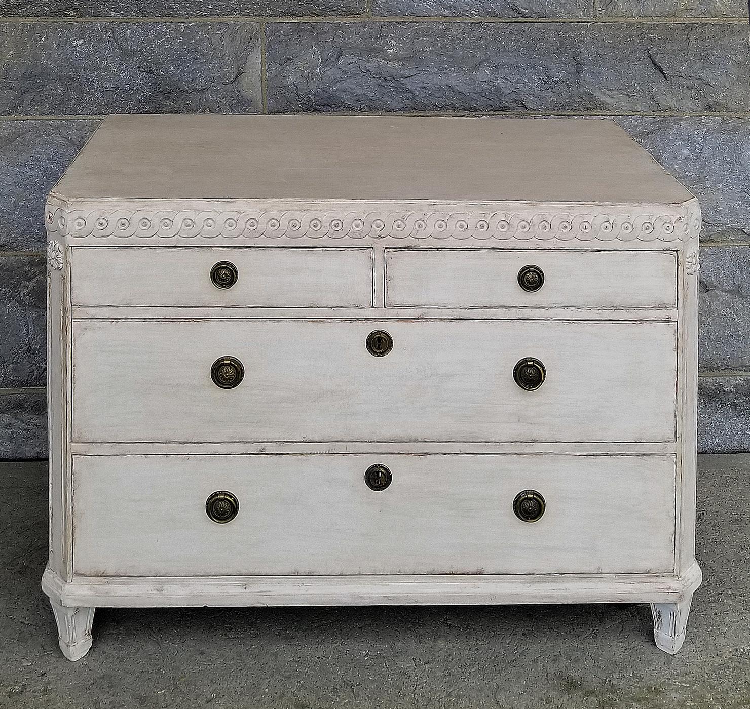 Gustavian style chest of drawers, Sweden circa 1880, with two over two drawers. Guilloche carving around the top, canted corners with applied rosettes, and tapering square feet. No repairs to this typically Swedish piece.
