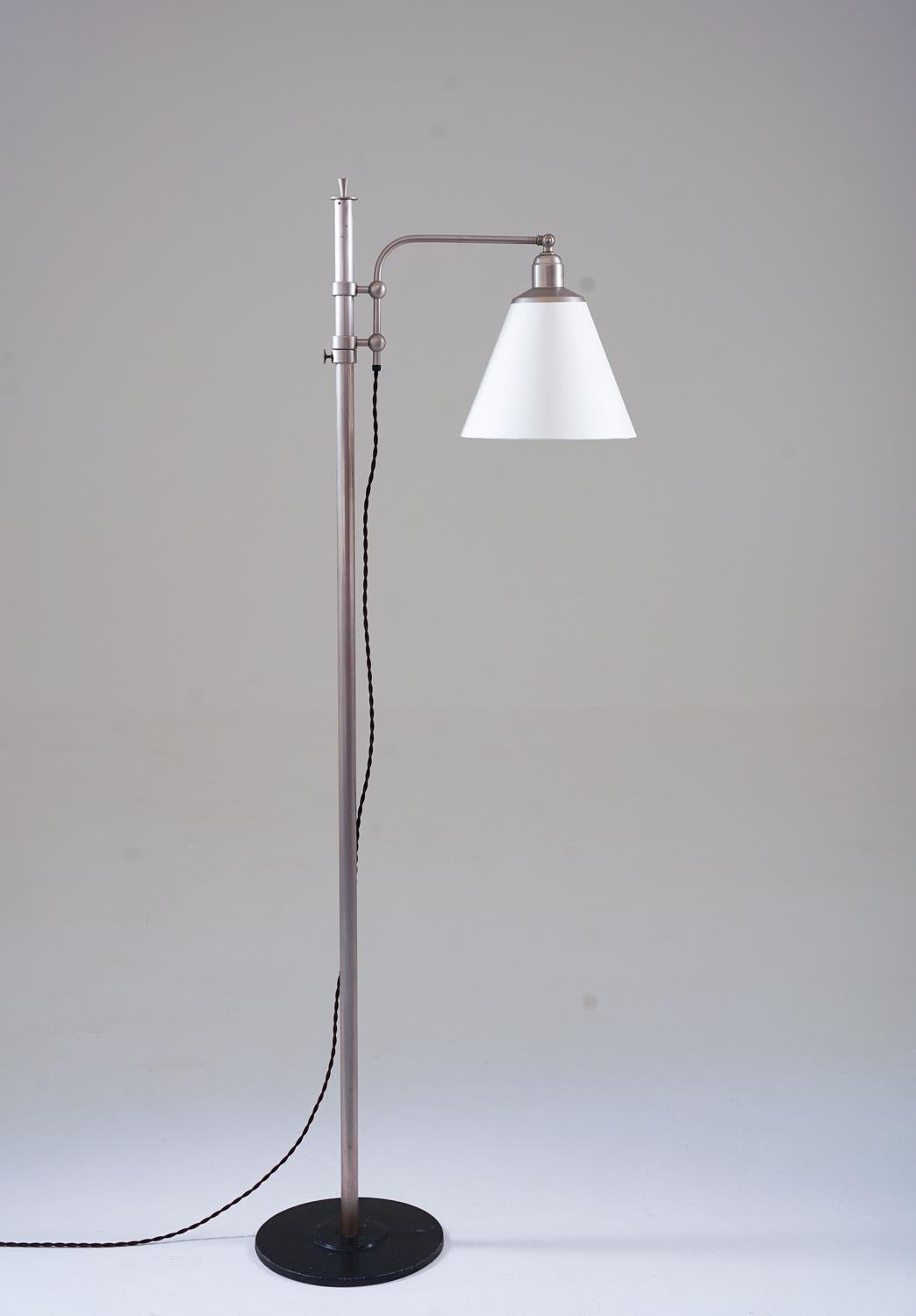 Lovely early functionalistic floor lamp manufactured in Sweden, 1930s. 
The lamp consists of a black iron base, supporting a metal tube with a swivel arm that holds the shade. 
Height is adjustable between 132-180cm (60-70.8”)

Condition: Good