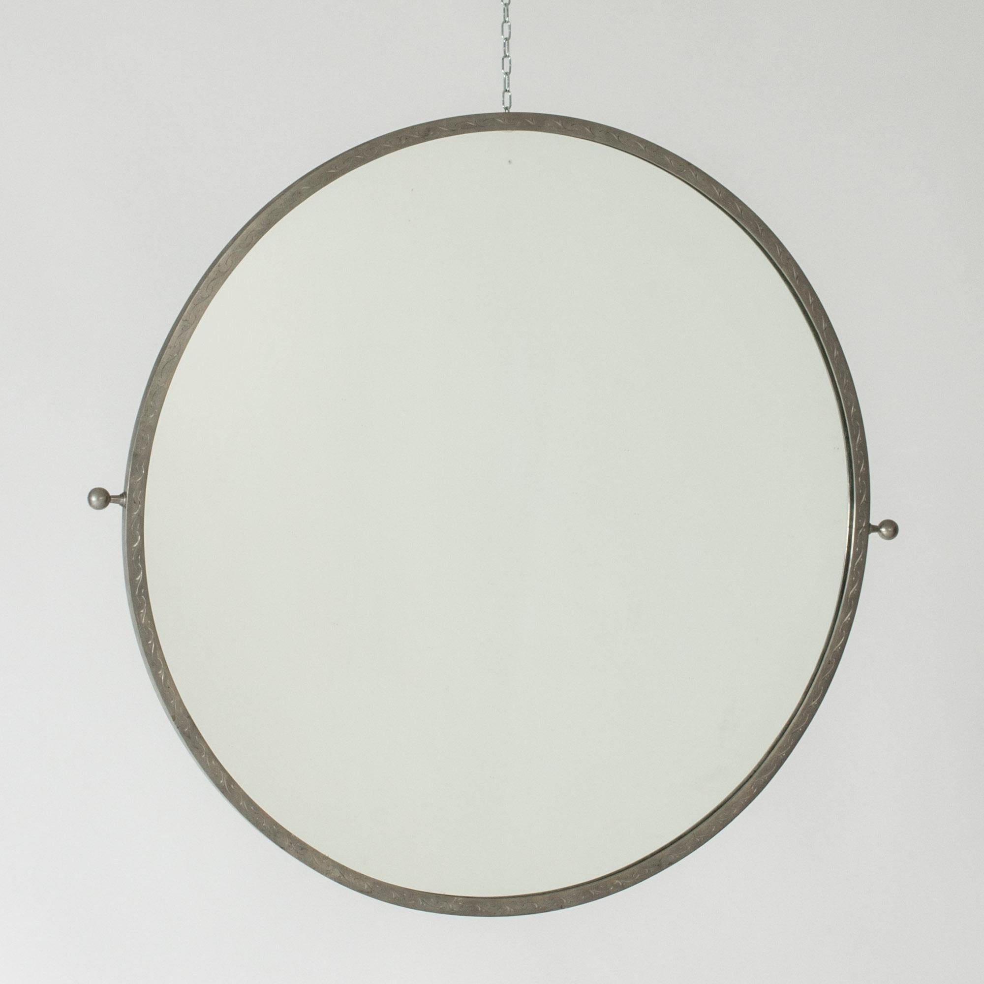 Elegant Swedish Modern pewter wall mirror. Large size, in a clean design with decorative details. Subtle pattern etched onto the frame, knobs on the sides.