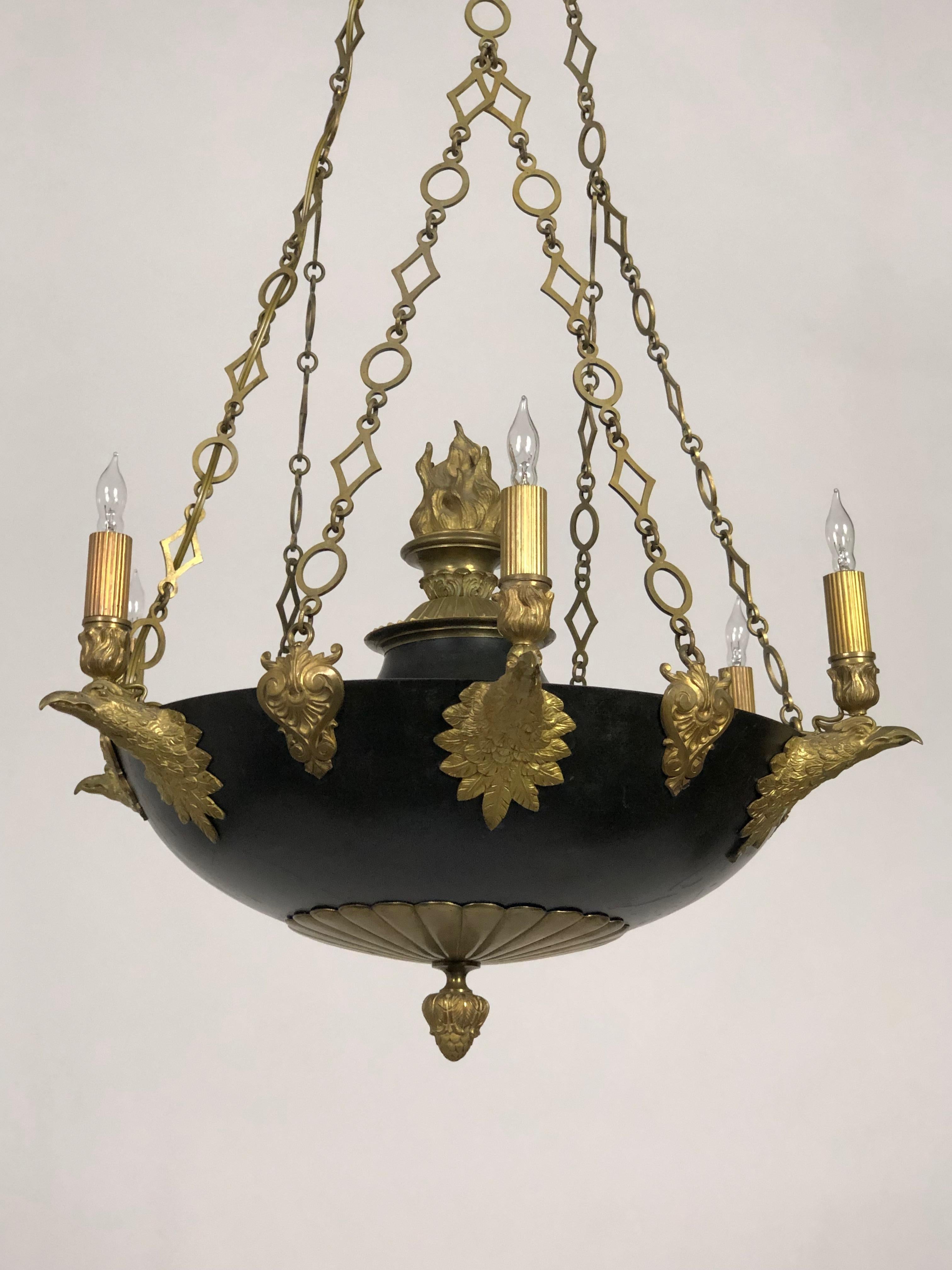 An Empire-style, black and gold chandelier made in Sweden circa 1830. In a bowl-form with 5 candle-style lights with finely cast, eagle head mounts. The chain, with circle and diamond links, adds a pleasing geometry to the piece. It's further