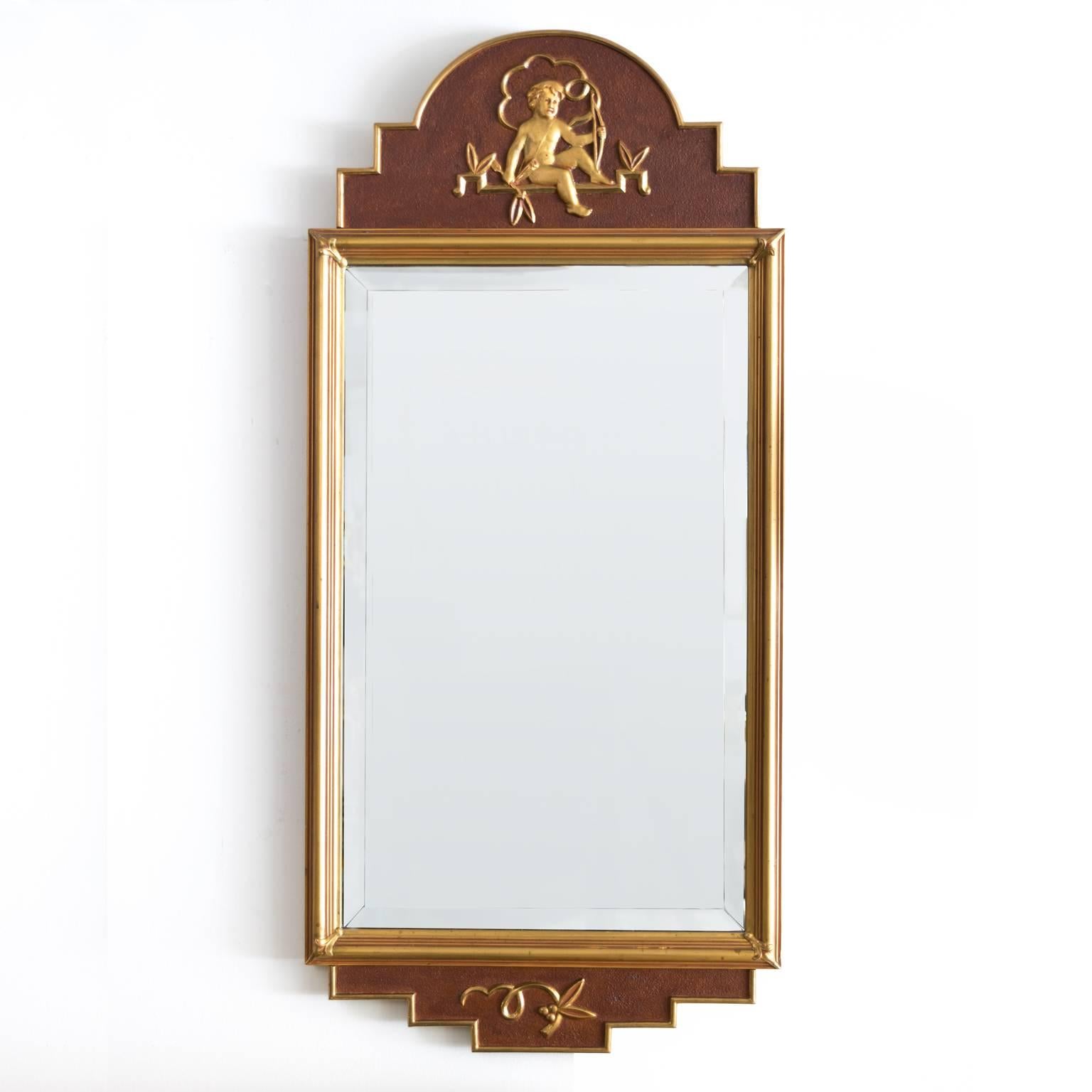 Swedish Art Deco mirror with gilt carved details which include a seated putto holding a bow, arrow and quiver against a faux mahogany painted gesso background. Made by W. Lundell, signed 1942.
 
Measures: Height 40.5