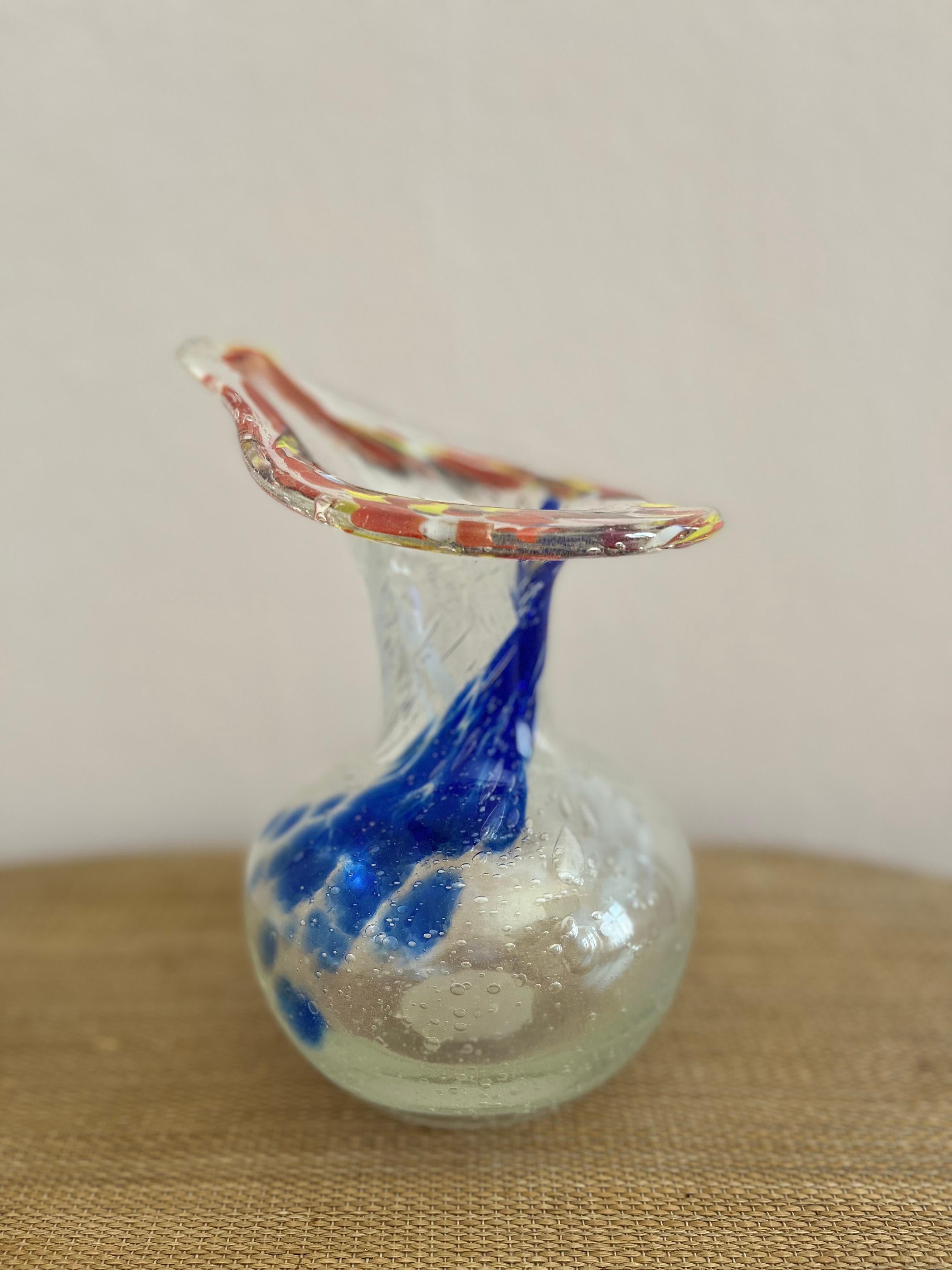 Swedish glass art vase in organic shapes.

Handmade Swedish glass art vase in clear, blue, orange, yellow and red. Bubbles in the glass, art glass piece.

Height: 20 cm (7.9 in). 