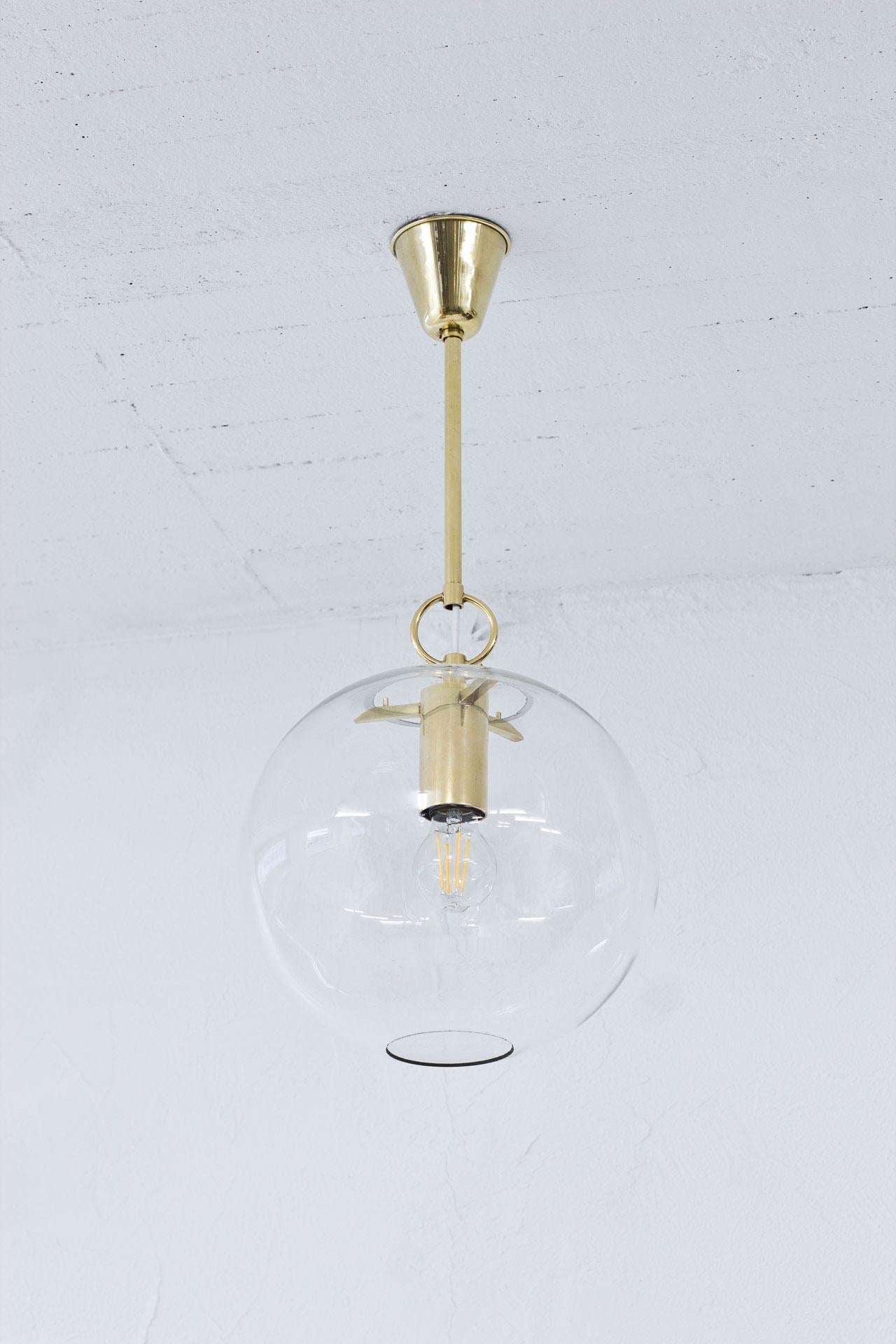 Lampe suspendue design/One  par Hans-Agne Agnes dans les années 1950. Fabriqué par sa propre entreprise à Markaryd, en Suède. La lampe est fabriquée en laiton avec un abat-jour en verre transparent d'origine.
L'électricité a été refaite. 