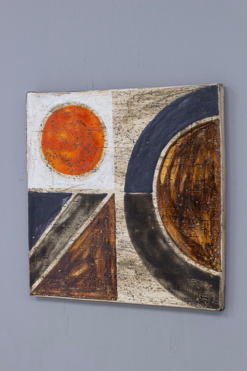 Beautiful glazed stoneware wall plaque/ tile designed by Mari Simmulson. Hand made at Upsala-Ekeby in Sweden during the beginning of the 1970s (most likely 1971). Made from stoneware, with a glazed abstract motif.
Stamped in the back by maker with a