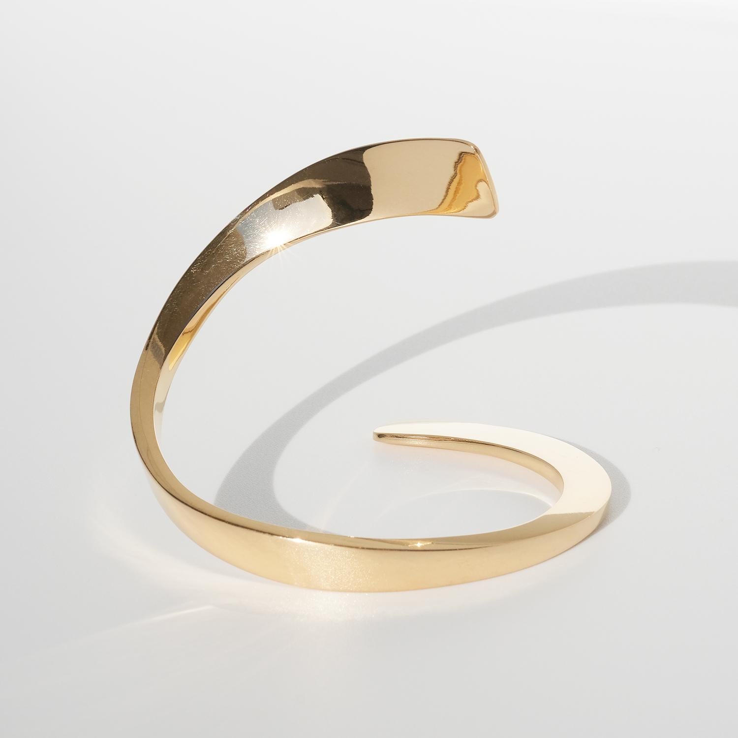 This cuff bracelet is made out of solid 18 karat gold and with that it has a beautiful shiny golden surface. Its arms embrace the wrist in such an exquisite and obvious way that it might be difficult to separate yourself from it once it's in