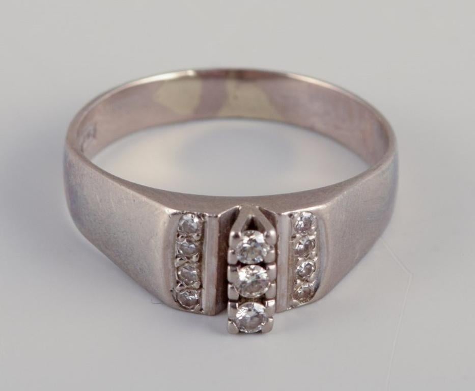 Swedish goldsmith. Ring in 18-karat white gold adorned with eleven diamonds.
Art Deco style.
Year stamp Y9. = 1973.
Master stamp BCG (Cedstam Guldsmed Bo, Stockholm) along with three crowns and 18K.
Perfect condition.
Dimensions: 18 mm / US size 7