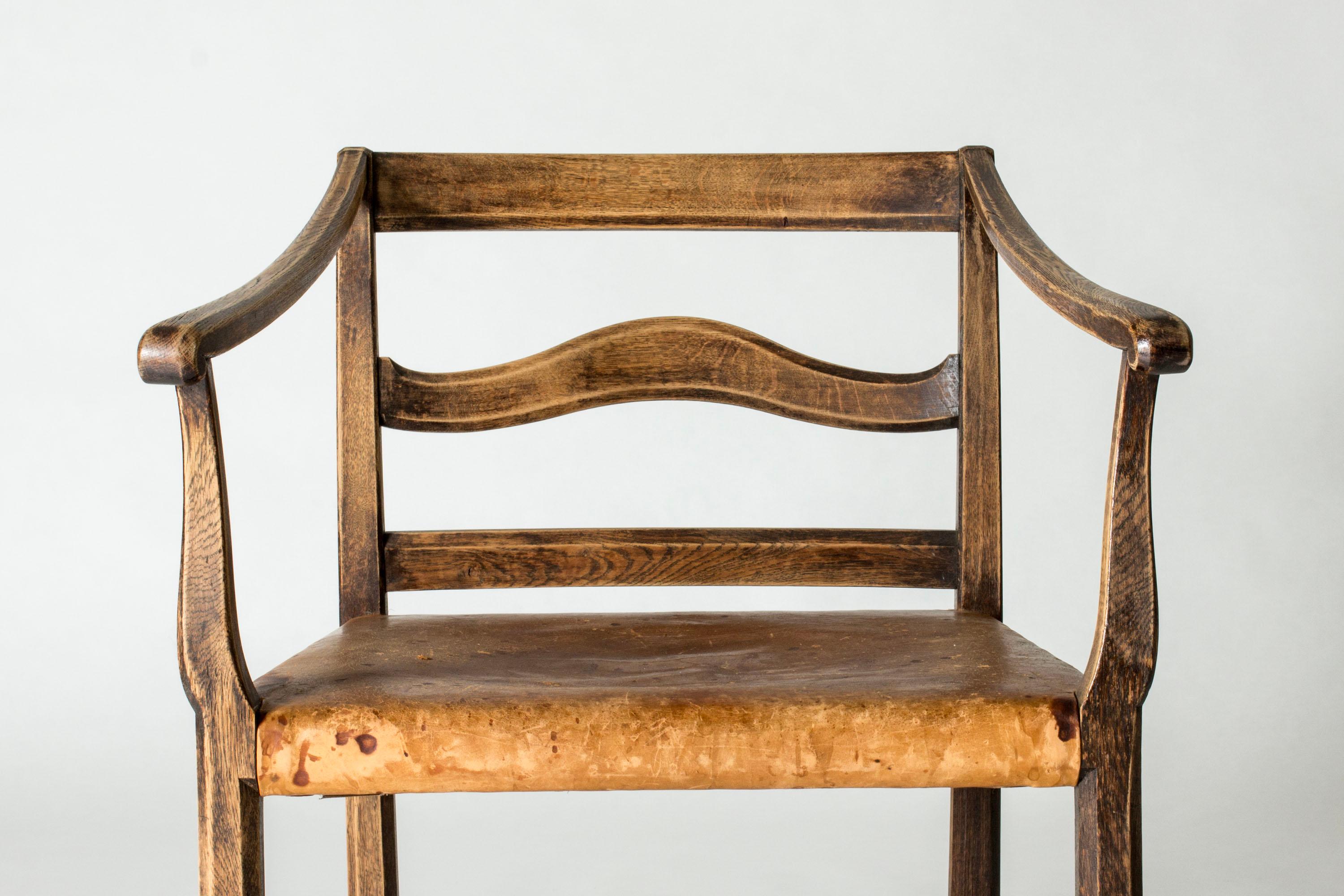 Beautiful Swedish Grace armchair by Carl Malmsten, made from oak with a leather seat. Clean lines, statuesque expression. Old leather with patina.