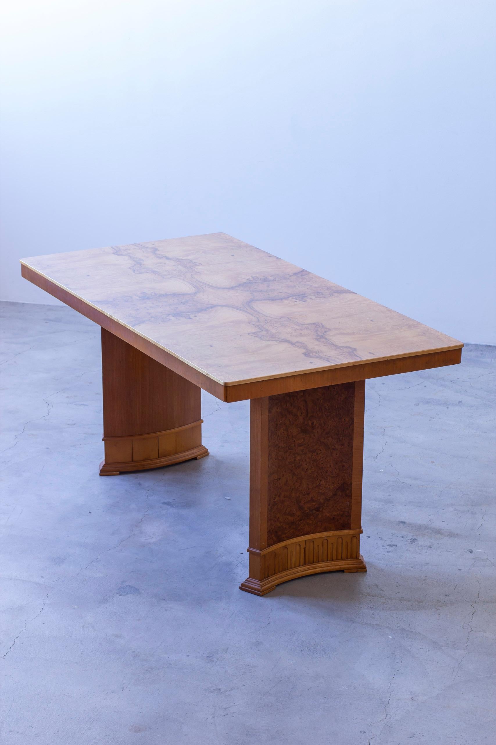Bureau de style art déco suédois dans le style d'Axel Einar Hjorth. Pieds néoclassiques en forme de colonne arquée en placage de racines d'orme avec un motif en forme de voûte sur le fond. Plateau de table en bouleau assorti à un livre exquis.