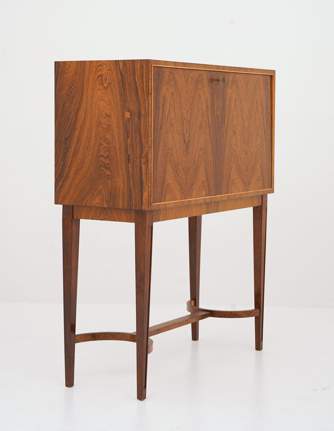 Stunning bar cabinet manufactured in Sweden, 1930s.
This bar cabinet is made with an impressive sense for material and design. The rosewood veneer creates a dramatic pattern on the front, and surrounded by a thin frame of birch it creates perfect