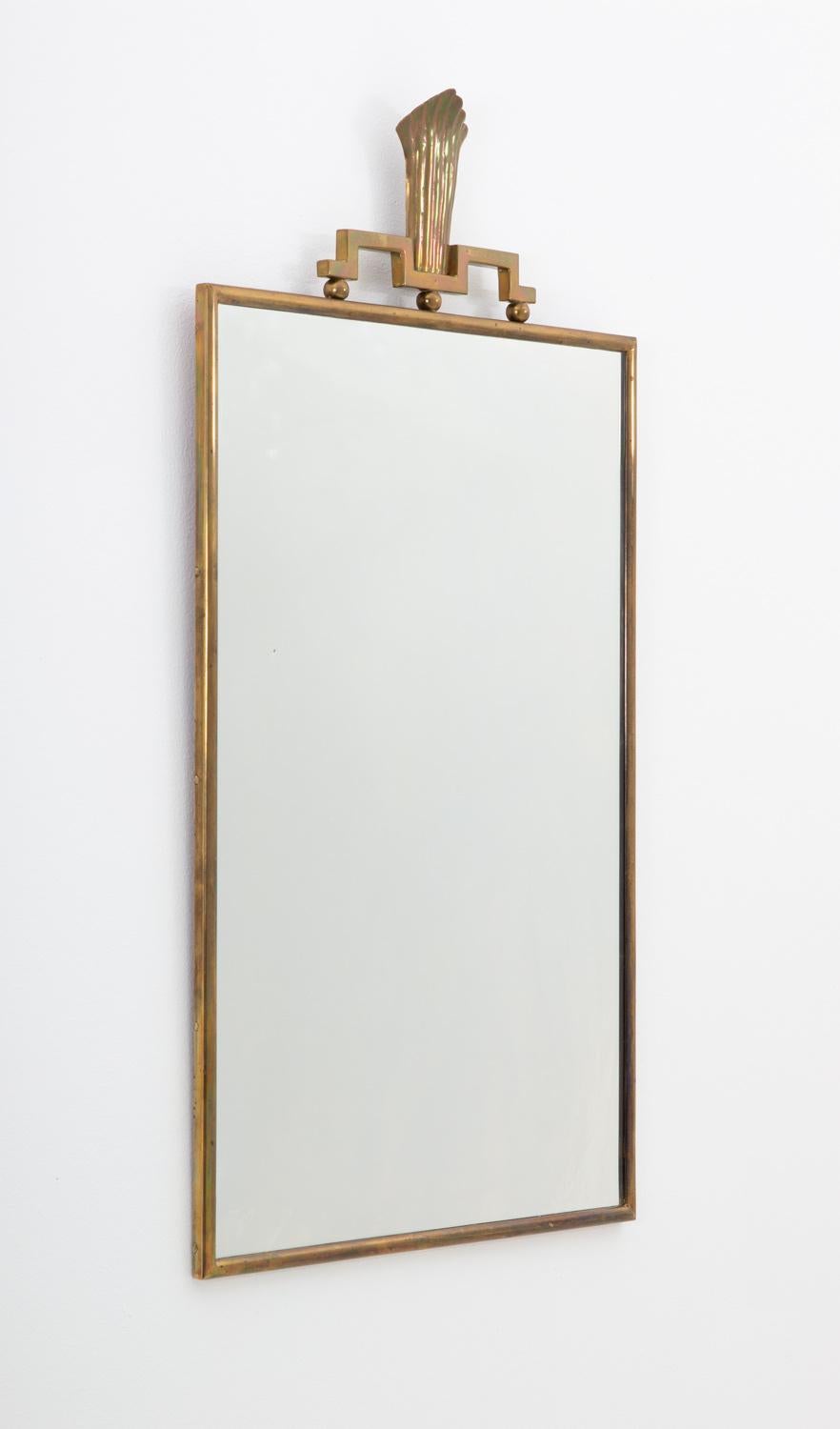 Beautiful and rare studio craft mirror produced by Lars Holmström, Sweden, 1930s. 
High-quality mirror with a brass frame. On top of the frame is a simple but elegant ornament, typical for Lars Holsmtröm´s work during this era.

Condition: Very