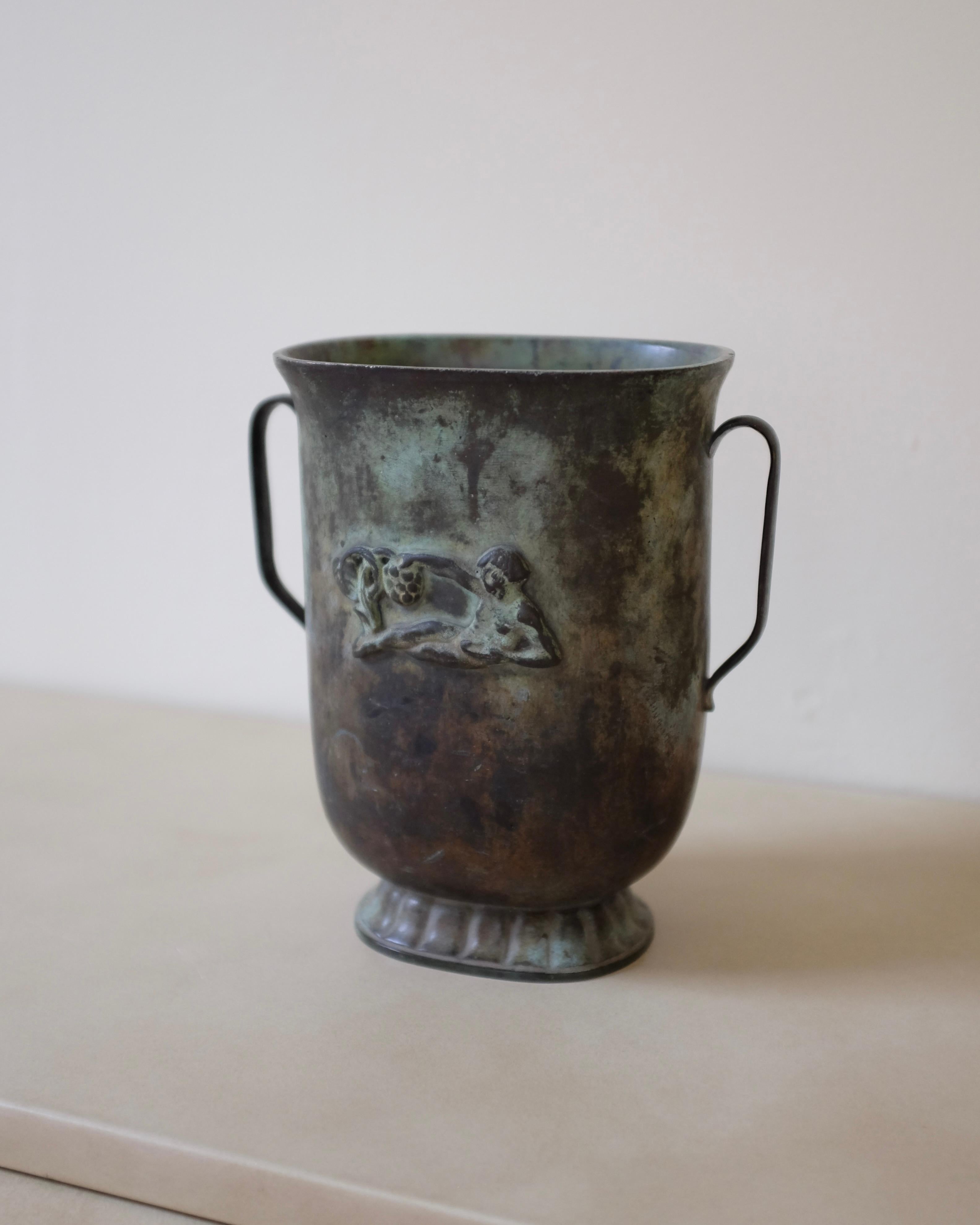 Precioso jarrón sueco Grace de bronce de GAB, Suecia. Fabricada hacia los años 30/40 y posiblemente diseñada por Just Andersen. Desgaste propio de la edad con hermosa pátina.

Dimensiones: Alto 7,4 pulg. x Ancho 7 pulg. x Fondo 4,1 pulg.