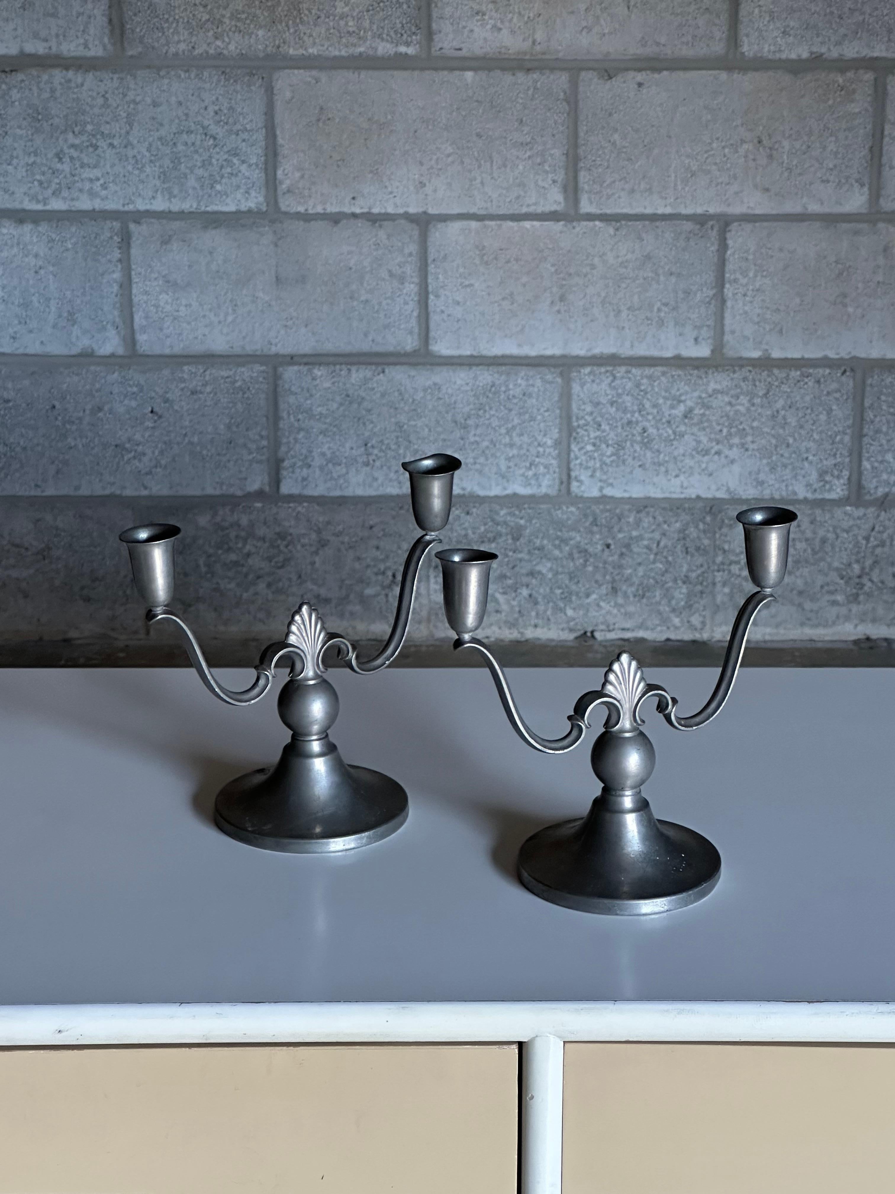 An early pair of pewter candelabras produced by Firma Svenskt Tenn, circa 1930s. Great organic form versatile size. Hard to find a matching early pair such as these. 