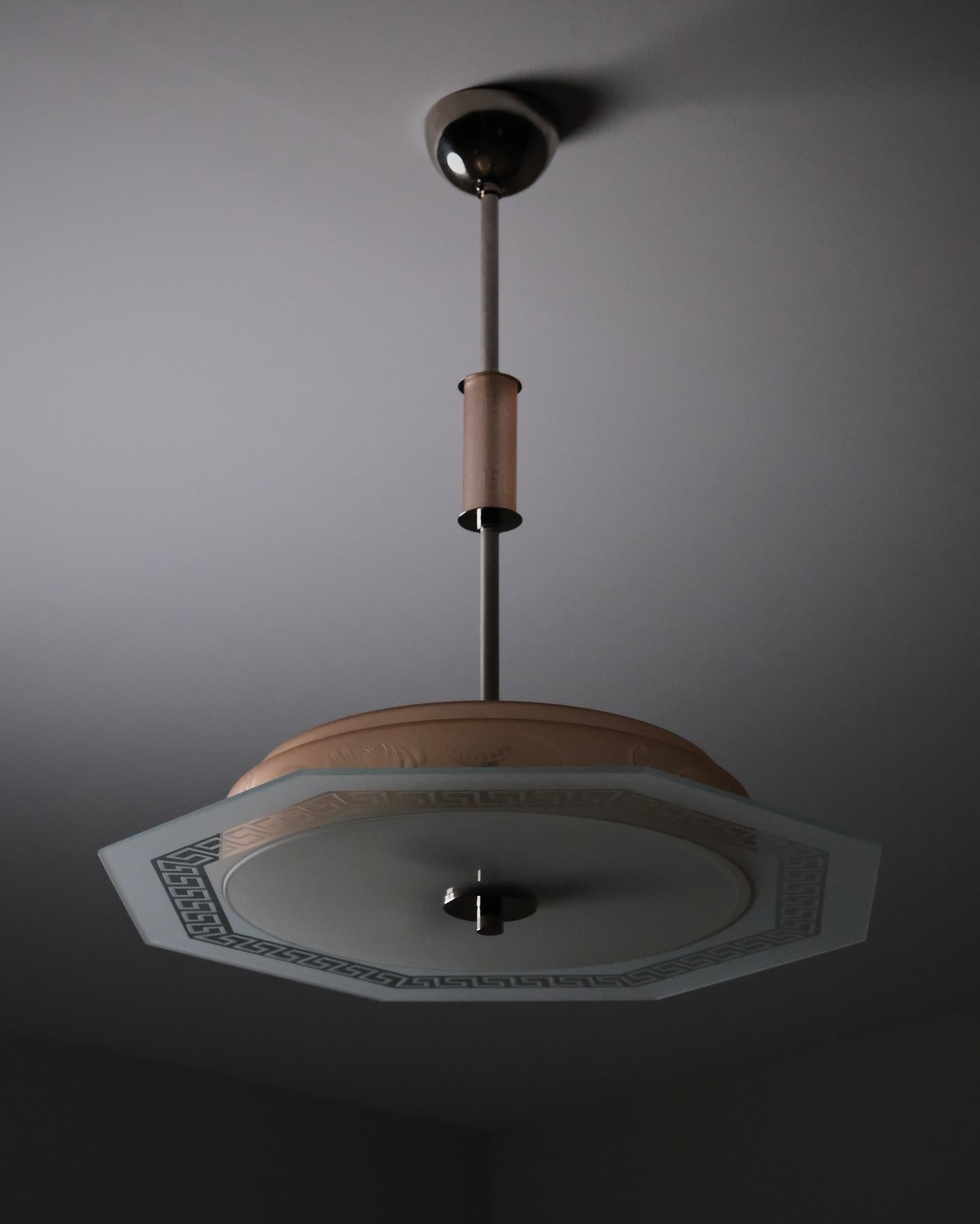 Élégant plafonnier de la période des Grâces suédoises, designer inconnu, produit en Suède dans les années 1940. Le design associe une géométrie classique à une ornementation subtile, caractéristique de la transition entre la décoration des années