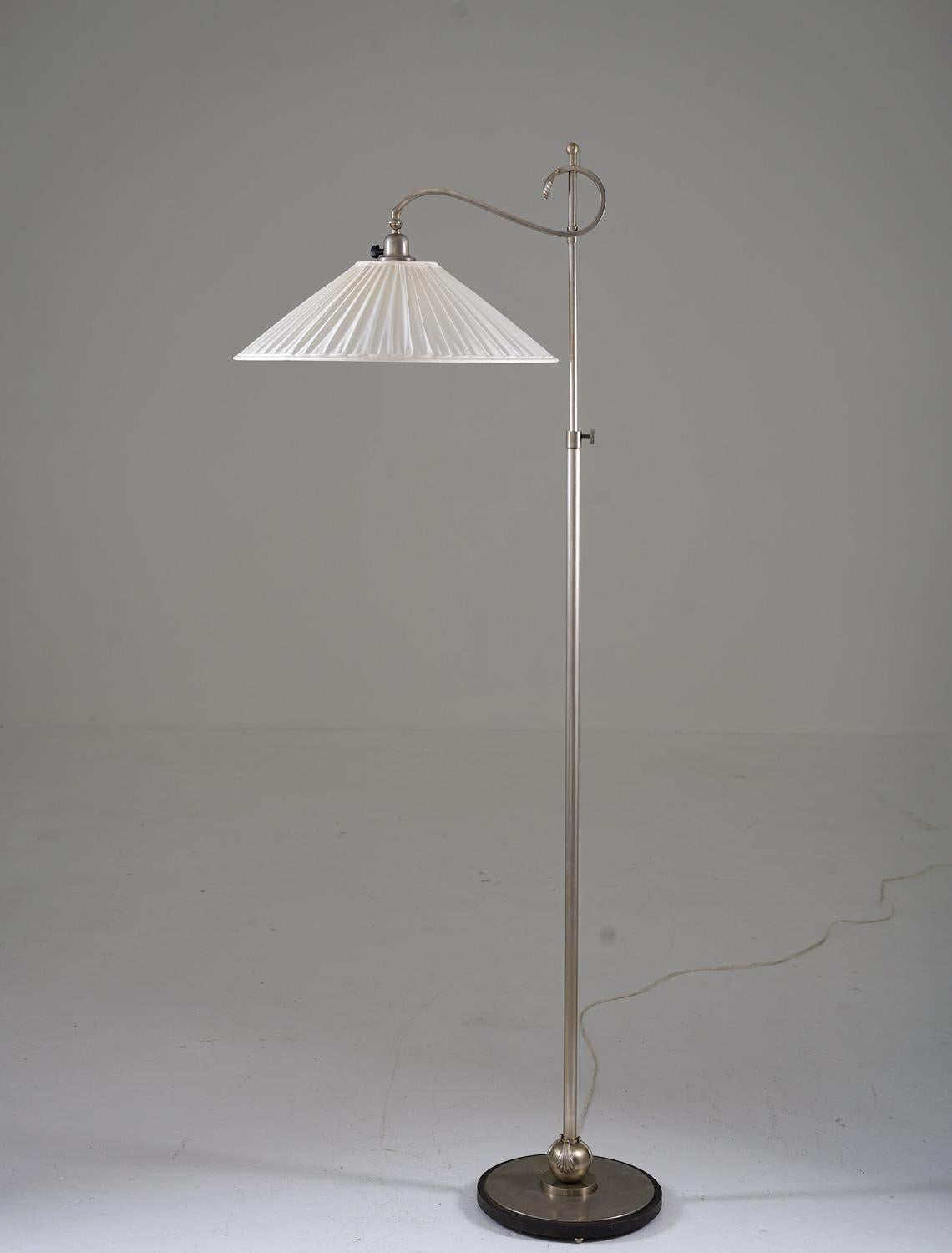 Lovely Swedish Grace floor lamp manufactured in the 1920s. 
This lamp is made of brushed steel and is constructed with impressive quality. The design is semi-minimalistic with beautiful details.
The height is adjustable and the maximum height is