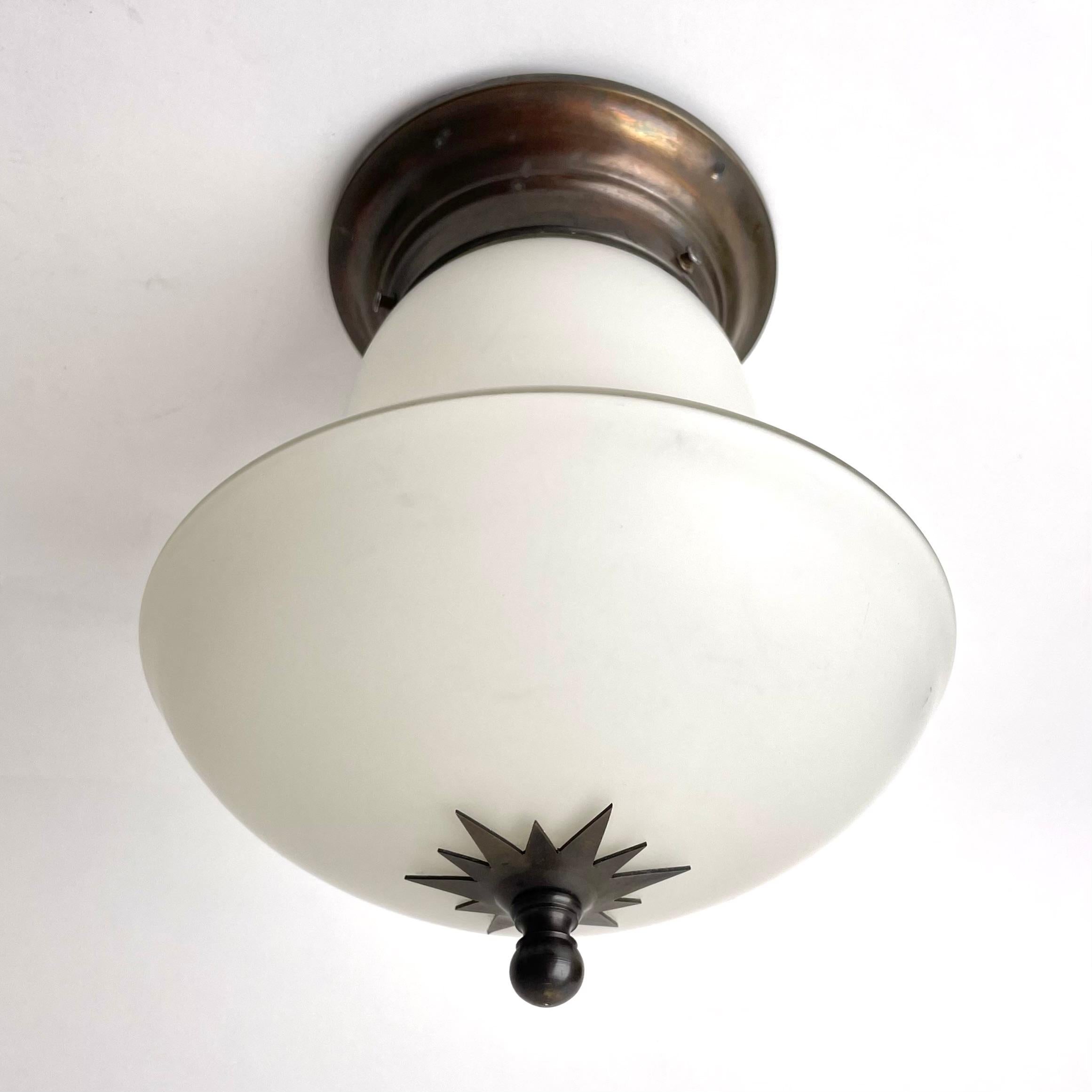 An elegant flush mount ceiling lamp made during the 1920s in Sweden in the refined Swedish Grace style, known for its refined interpretation of stylized classicism, while reflecting modern sensibilities in terms of materials and form. It consists of