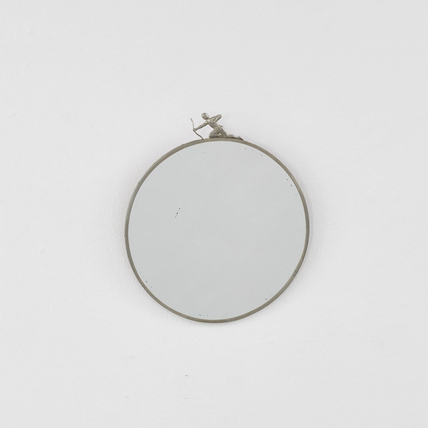 A charming round pewter mirror, crowned by a diminutive archer with bow drawn. The piece is typical of the Swedish Grace movement, a lesser-known Scandinavian branch of Art Deco that beautified geometric silhouettes with simple decorative flourishes.
