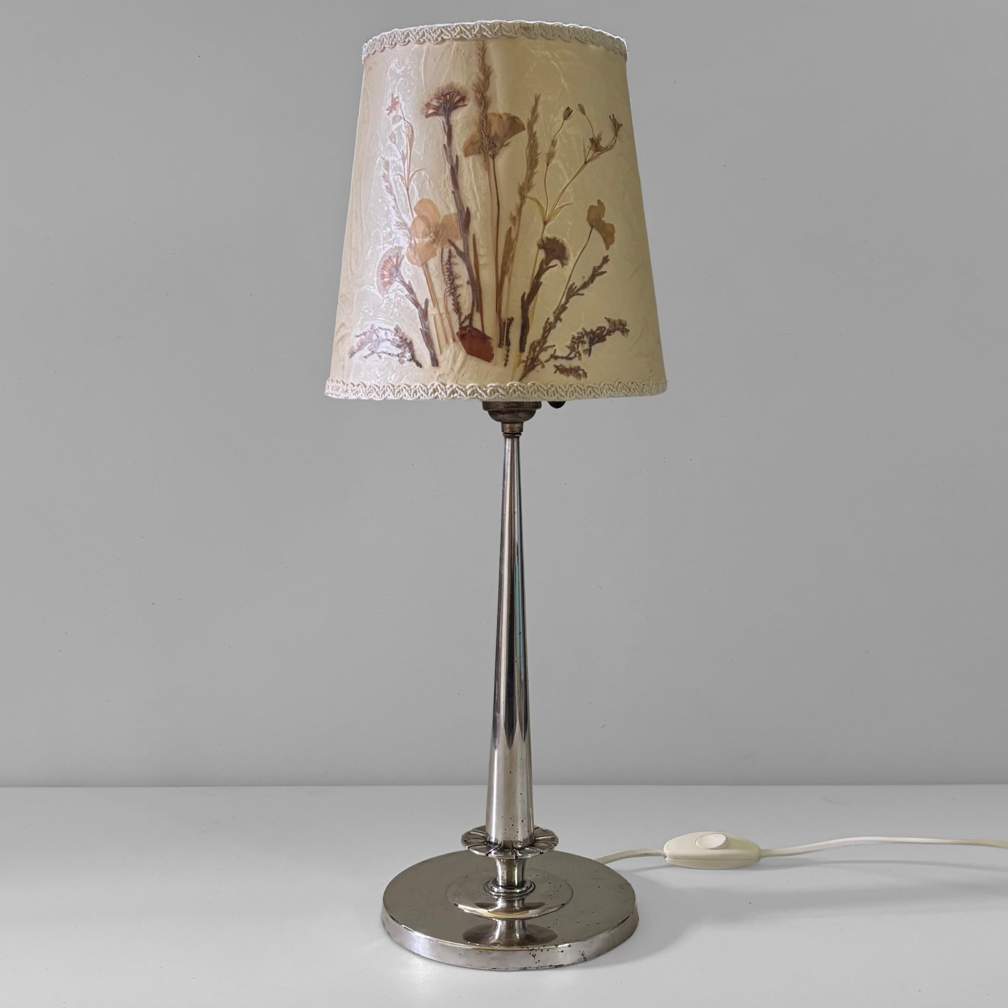 Eine schöne skandinavische neoklassizistische Tischlampe aus den 1920er Jahren, hergestellt von der renommierten schwedischen Silberschmiede CG Hallberg in Stockholm. Sie hat einen schlanken Stiel, der auf einem runden Fuß steht, und ist mit der