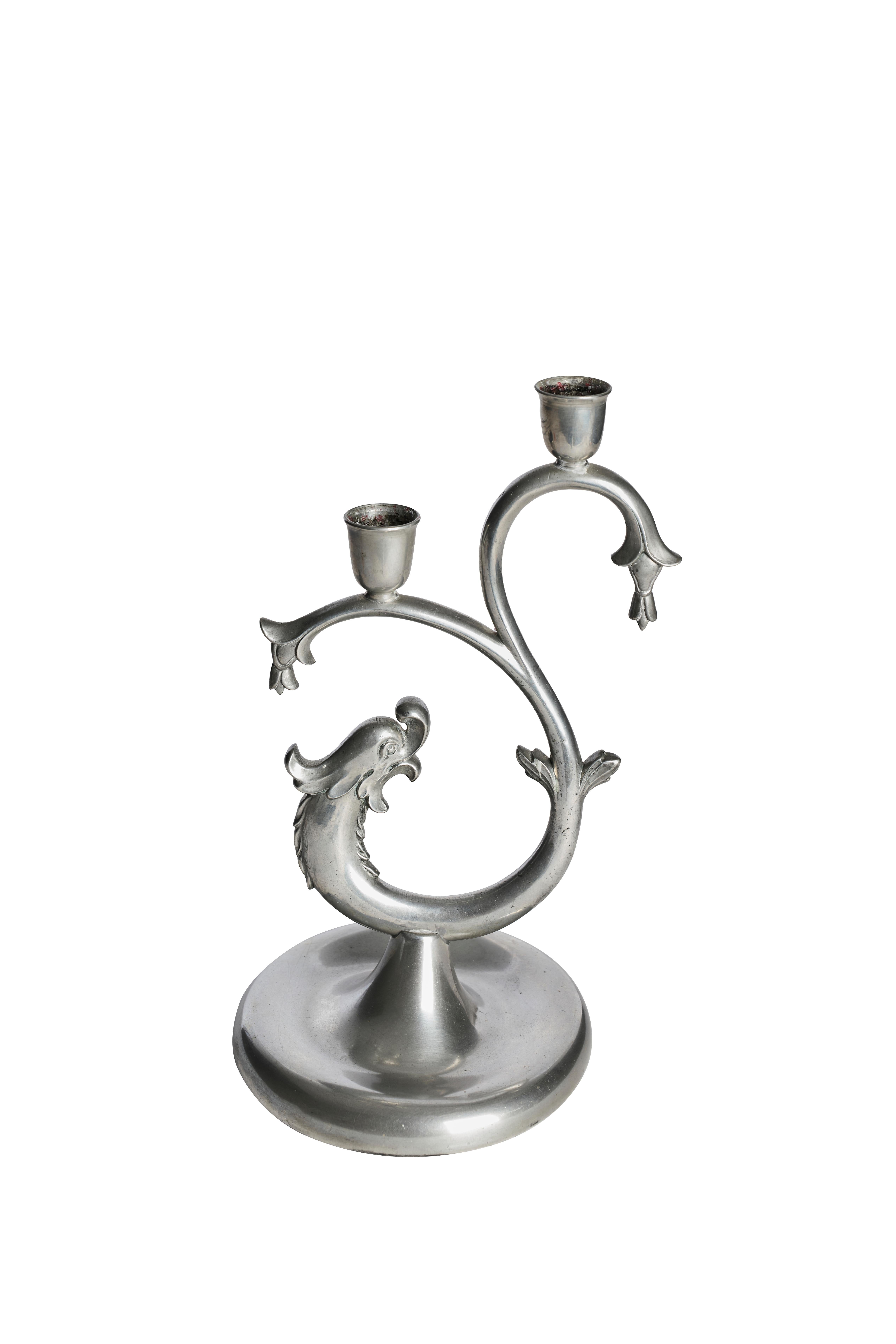 Elegante e scultorea coppia di portacandele disegnata da Knut Eriksson & Co, Svezia, datata 1932.

Ogni candeliere è fuso in un morbido metallo argentato con una caratteristica silhouette a spirale, con motivi di pesci o delfini stilizzati - un