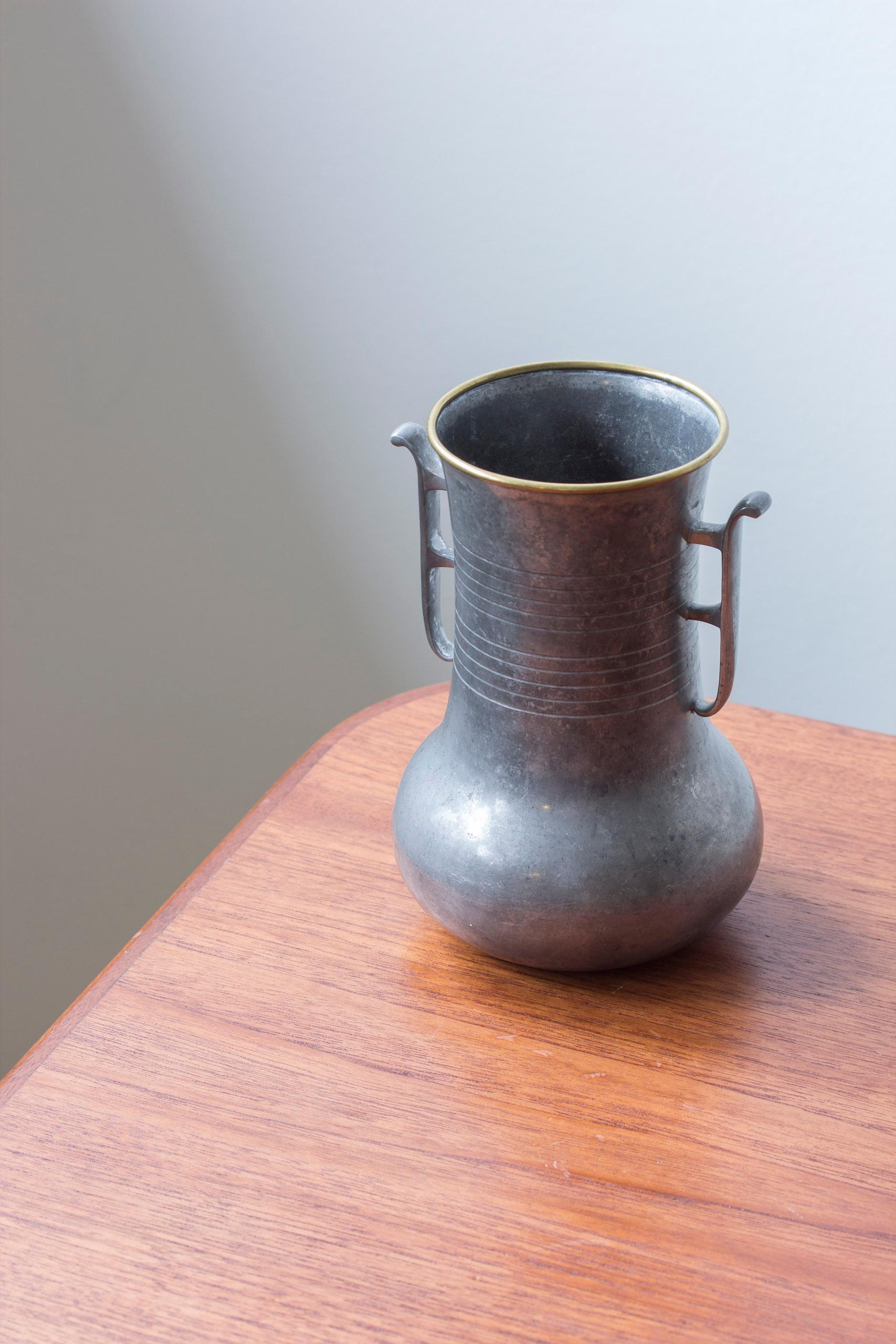 Vaso in peltro e ottone prodotto da GAB. Realizzato a Stoccolma, in Svezia, nel 1931. Design elegante con decorazioni a righe e bordo in ottone. Buone condizioni vintage con usura e patina legate all'età.



Progettista: Sconosciuto

Produttore: GAB