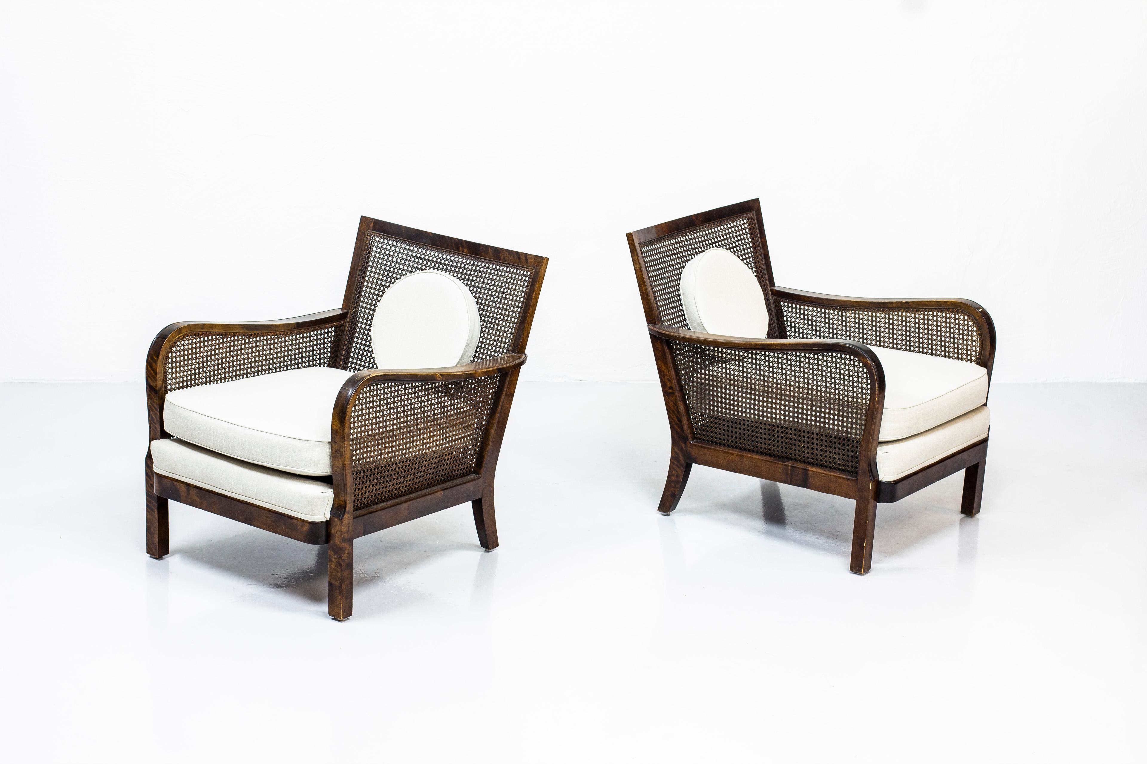 Pair of lounge chairs attributed to Otto Schulz. Most likely produced by Boet in Gothenburg, Sweden during the 1930s-1940s. Made from stained birch and rattan. With New linnen upholstery. Very good vintage condition with light age related wear and