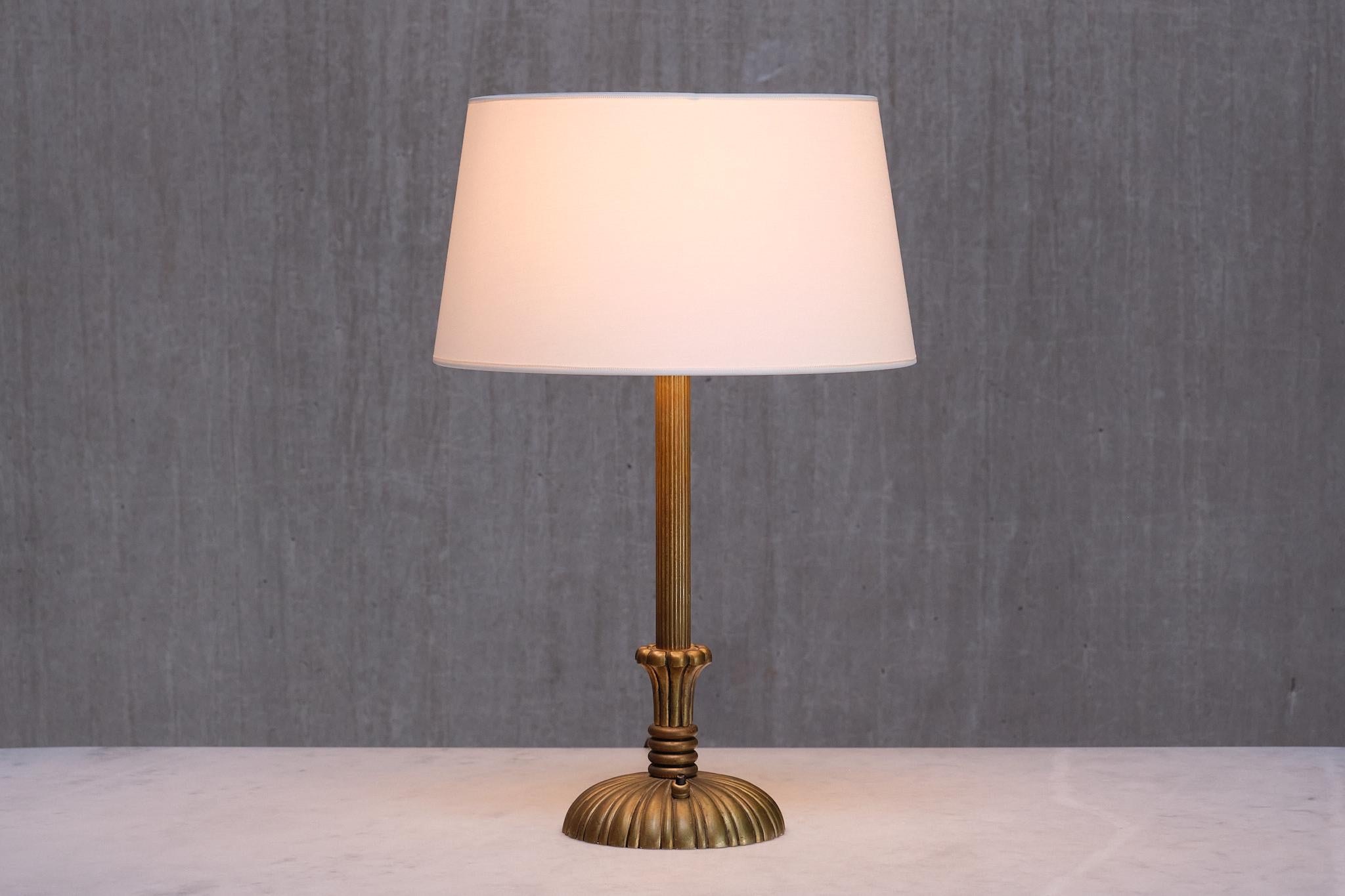 Cette élégante lampe de table a été conçue et produite en Suède au milieu des années 1930. 

Le design décoratif est entièrement fabriqué en laiton massif, qui a développé une belle patine uniforme au fil du temps, créant un aspect plus mat. La