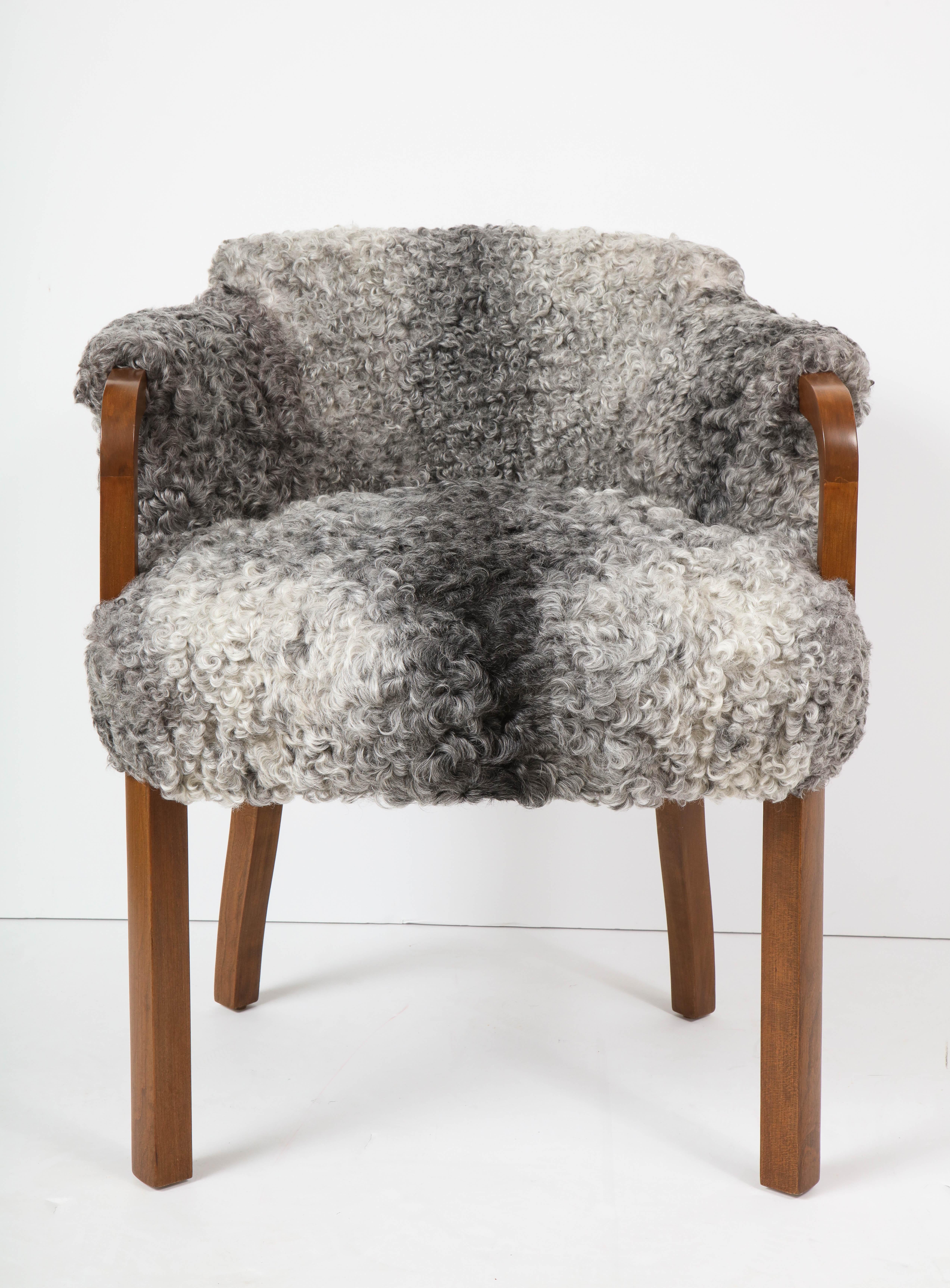 Pair of Art Deco/Swedish grace Walnut club chairs upholstered in grey curly sheepskin. Mint restored condition. Arm height is 27.5 inches.