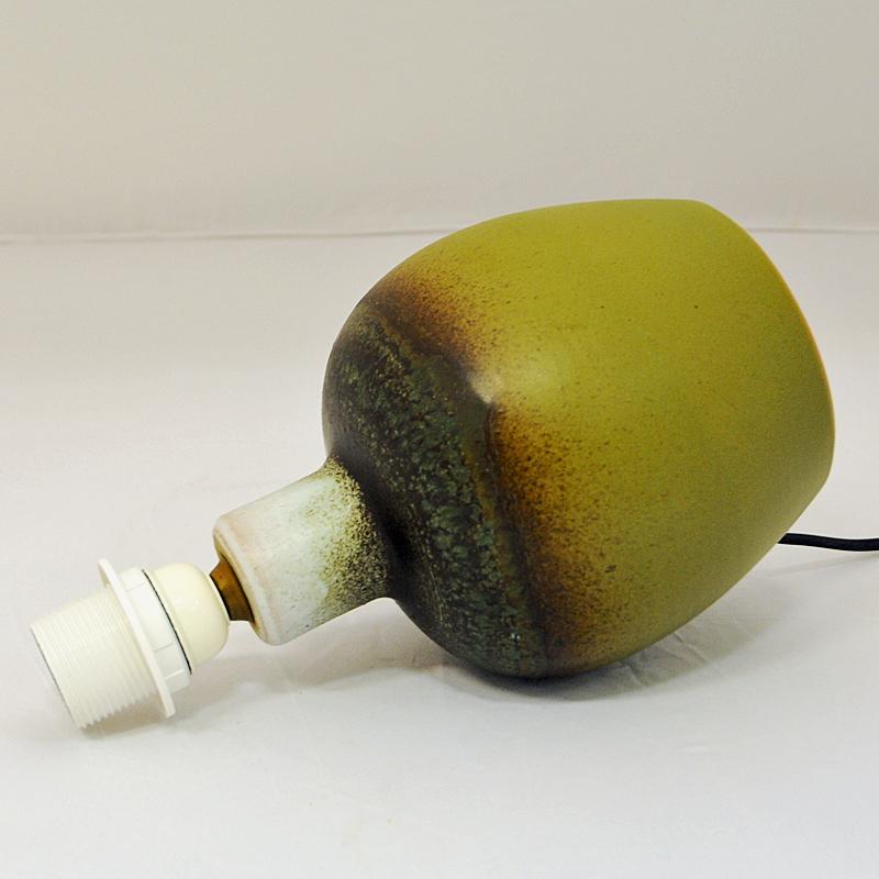 Special oval shaped tablelamp of green pained glazed ceramic made by Tilgman Keramik, Sweden 1960s. A vintaget table lamp with pear design and blended shades of brown and green colors. Signed underneath by Tilgman.
Measures included shade: H: 39cm