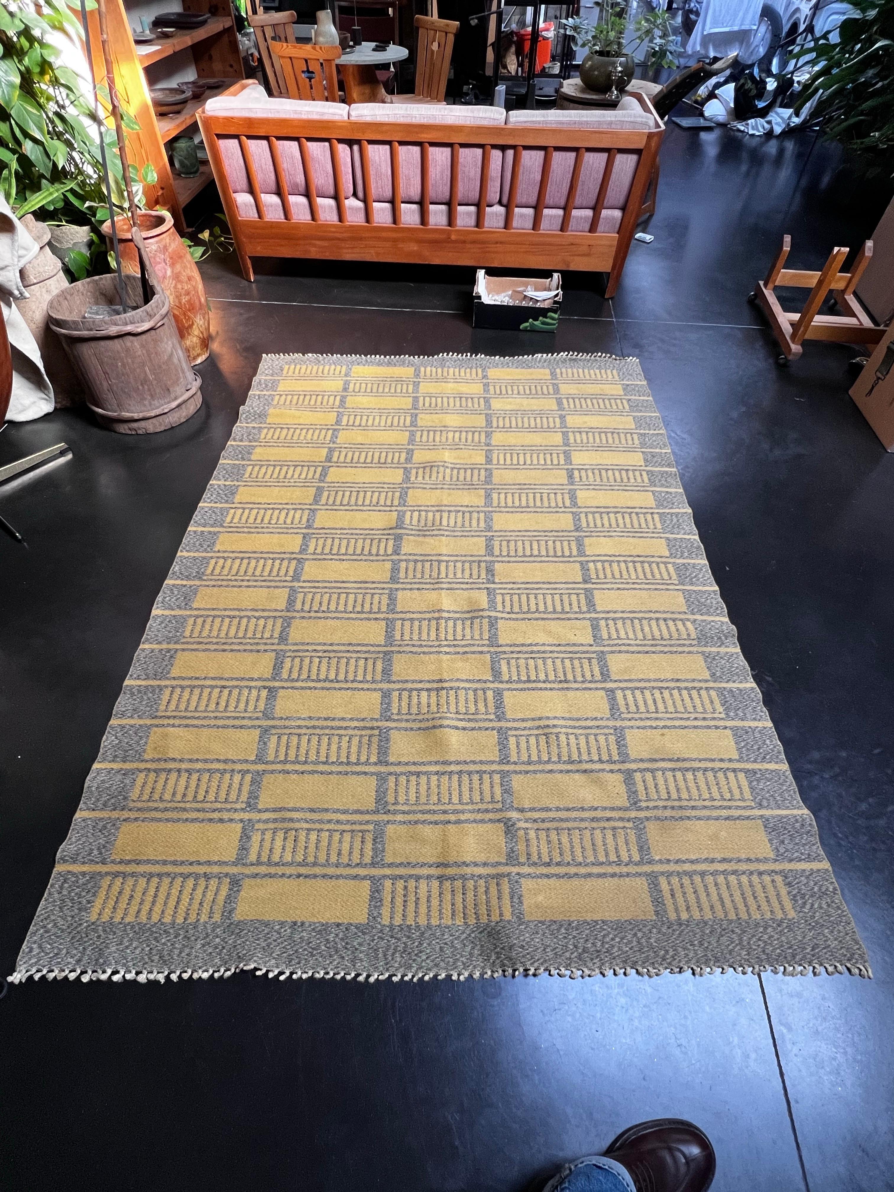 Eleganza svedese in grigio e giallo con motivi geometrici. Realizzato in lana. È molto morbido e in ottime condizioni per la sua età. Progettato e prodotto negli anni '50. Tutte le frange sono in buone condizioni. Sarebbe un'ottima aggiunta in