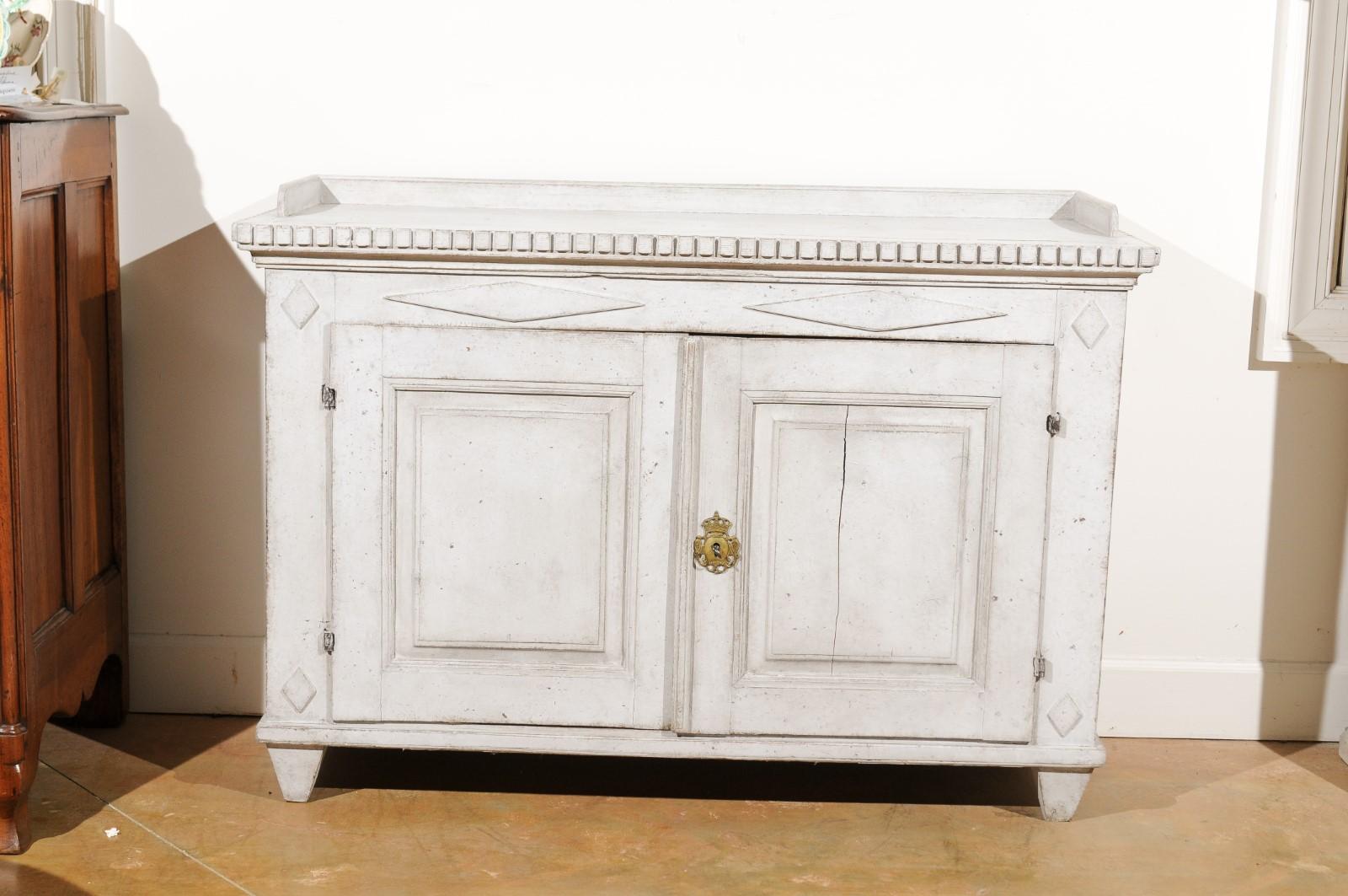 A Swedish Gustavian period painted sideboard from the late 18th century, with diamond patterns, dentil molding, original locks and hardware. Created in Sweden during the last decade of the 18th century, this Gustavian sideboard features a