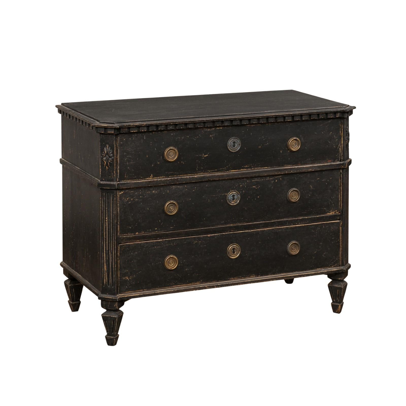 A Swedish Gustavian period black painted chest of drawers from the early 19th century, with dentil molding and carved side posts. Created in Sweden during the second quarter of the 19th century, This Gustavian chest features a rectangular, slightly