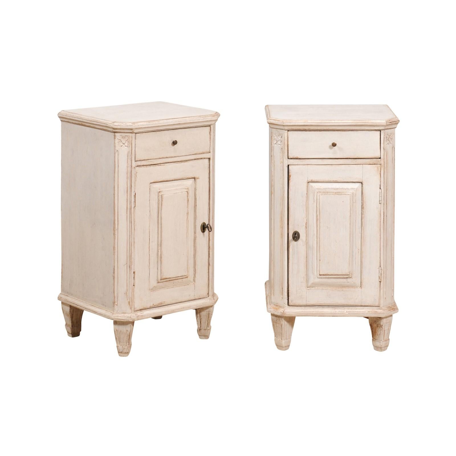 A pair of Swedish Gustavian style bedside tables from circa 1880 with light gray finish, single drawer over single door, canted side posts and tapered feet. This pair of Swedish Gustavian style bedside tables from circa 1880 exudes the serene
