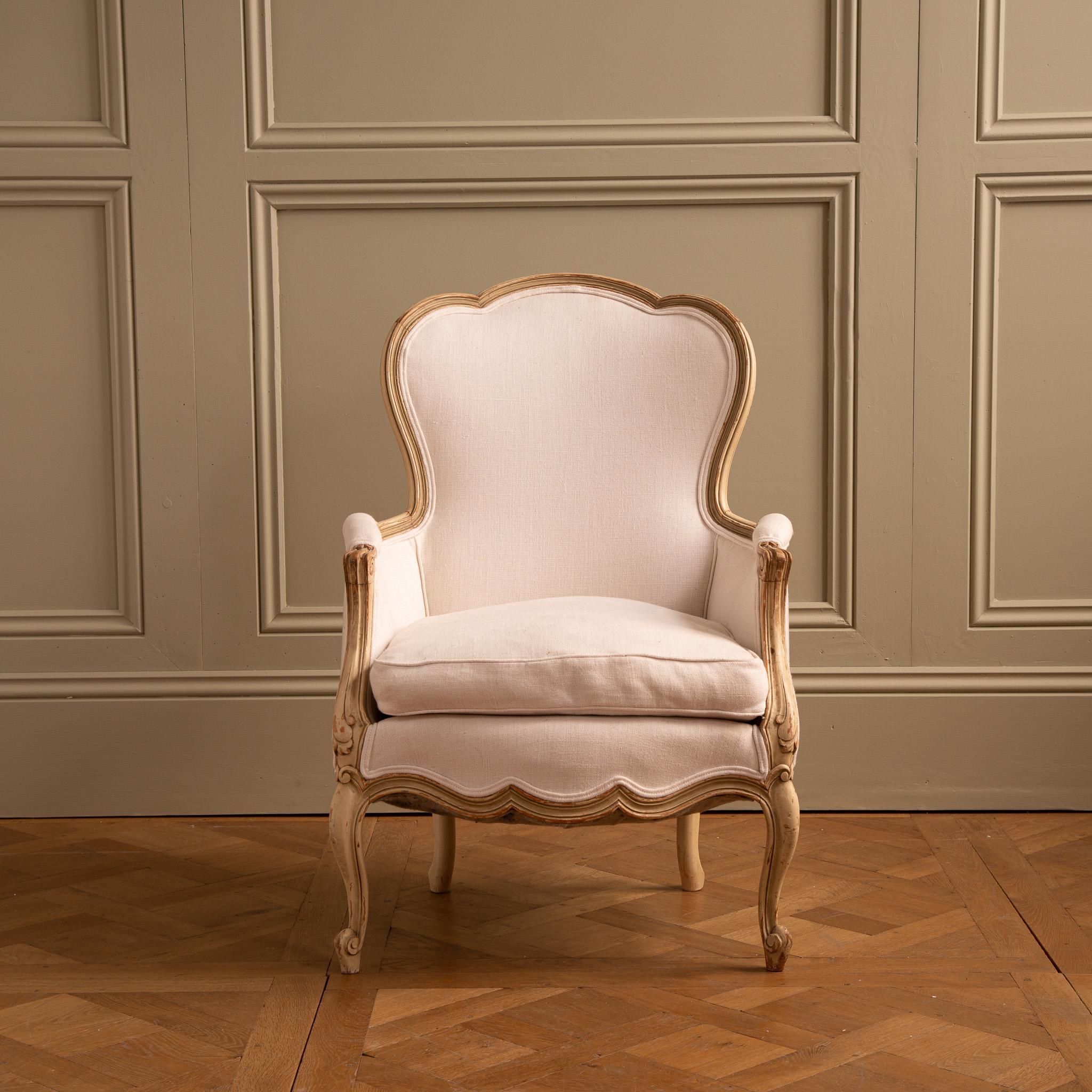 A Swedish, Gustavian style arm chair from the early 1900's, carved in solid beech wood and hand painted in a warm white which has naturally aged to reveal some of the wood beneath. The chair has comfortable proportions with a feather cushioned seat