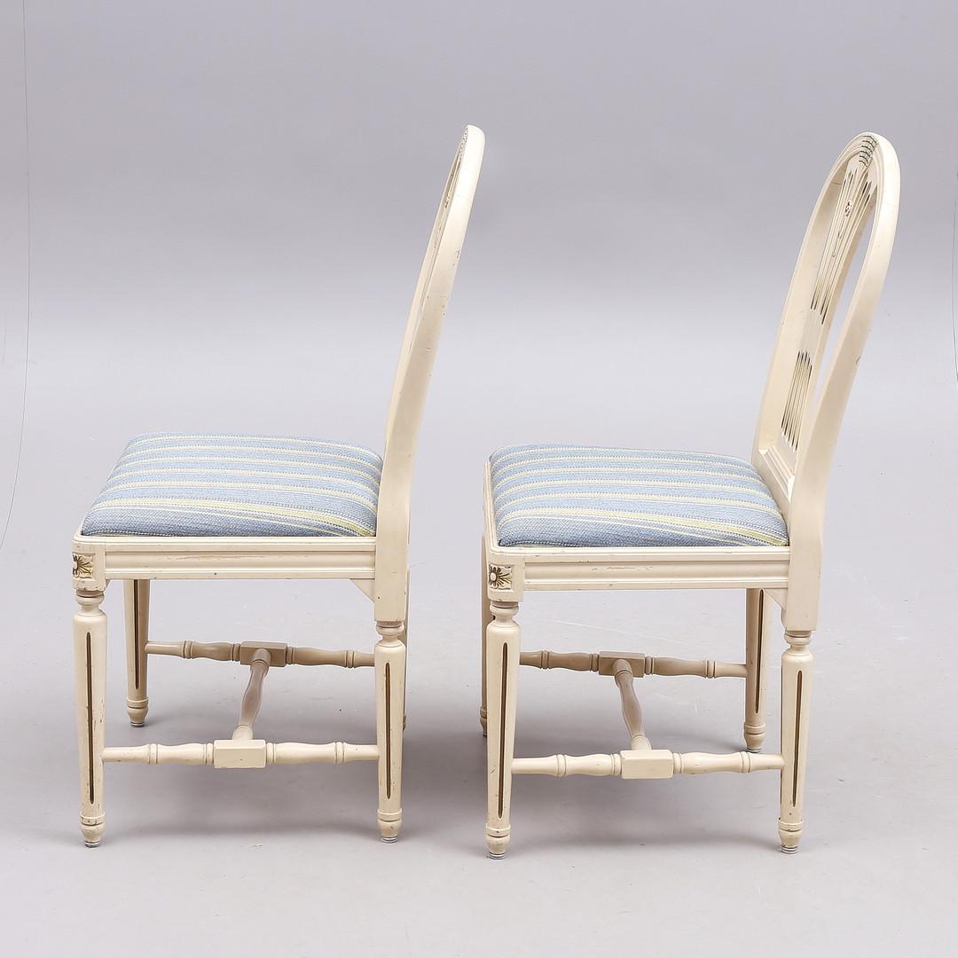 Unusual early second half of the 20th century set of 4 Gustavian axet dining chairs in distressed paint finish with wheatsheaf motifs.

Lovely detail in the fluted legs and rosettes with carved front edge and trap seats for added comfort.

The