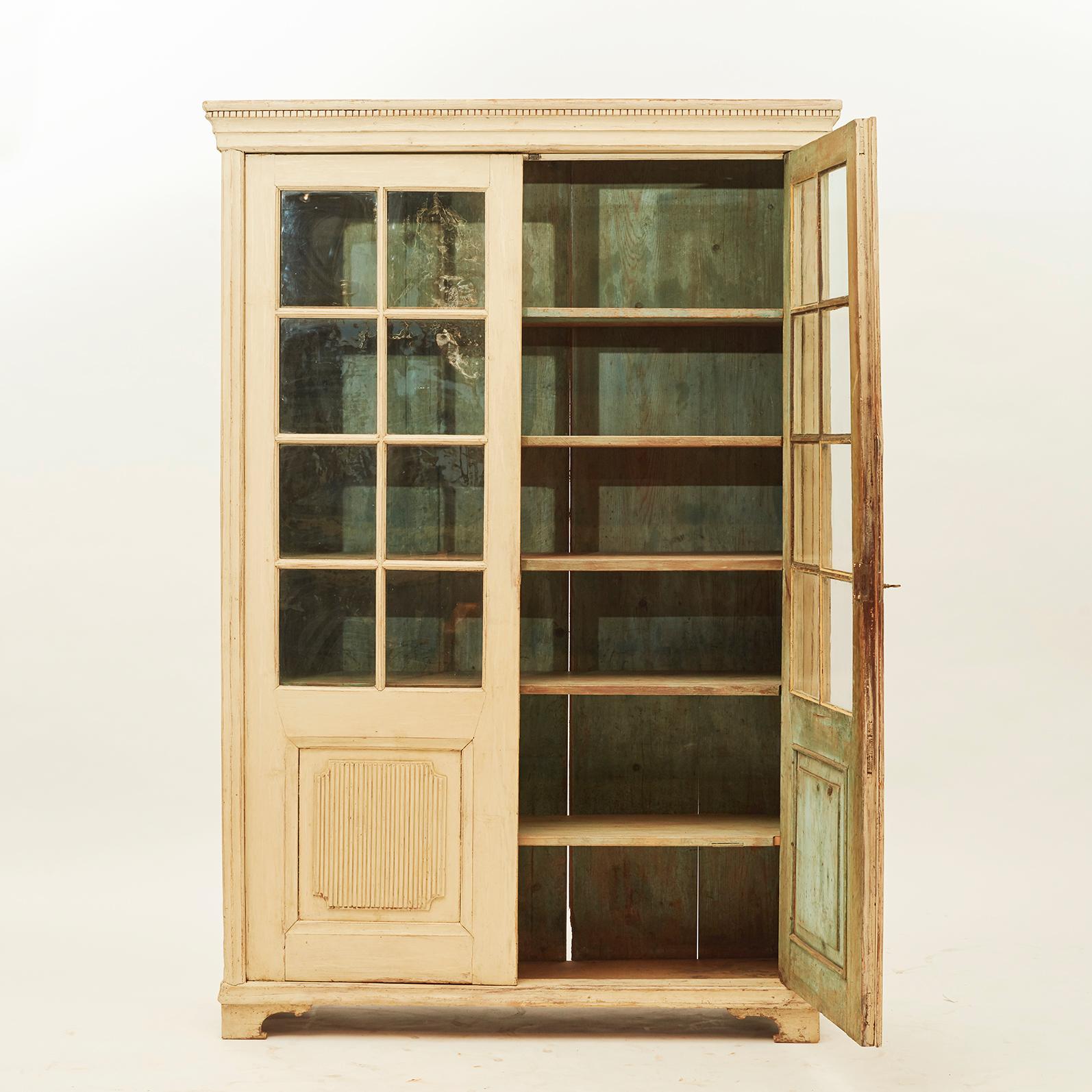 A Swedish Gustavian glass cabinet, circa 1820. Pair of doors with slats. Bottom with canned fillings. Light yellow color, inside blue or green color. A charming cabinet with good natural patina. Sweden 1820-1830.