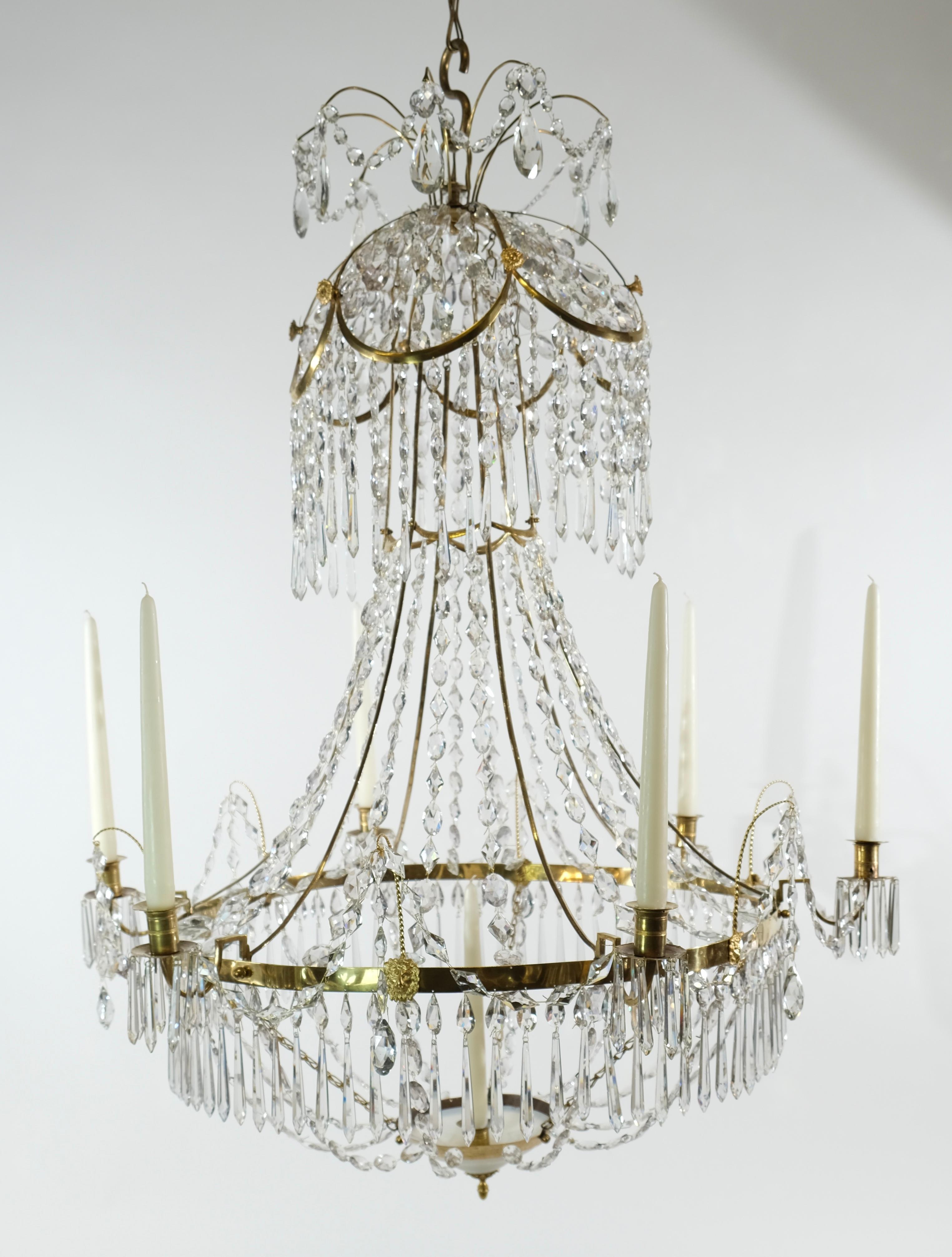 A Swedish Gustavian chandelier made around year 1810. It has six candleholders around the ring and one inside the white bowl at the chandeliers bottom. This was called the saving light. Candles were expensive in those days and usually you just lit