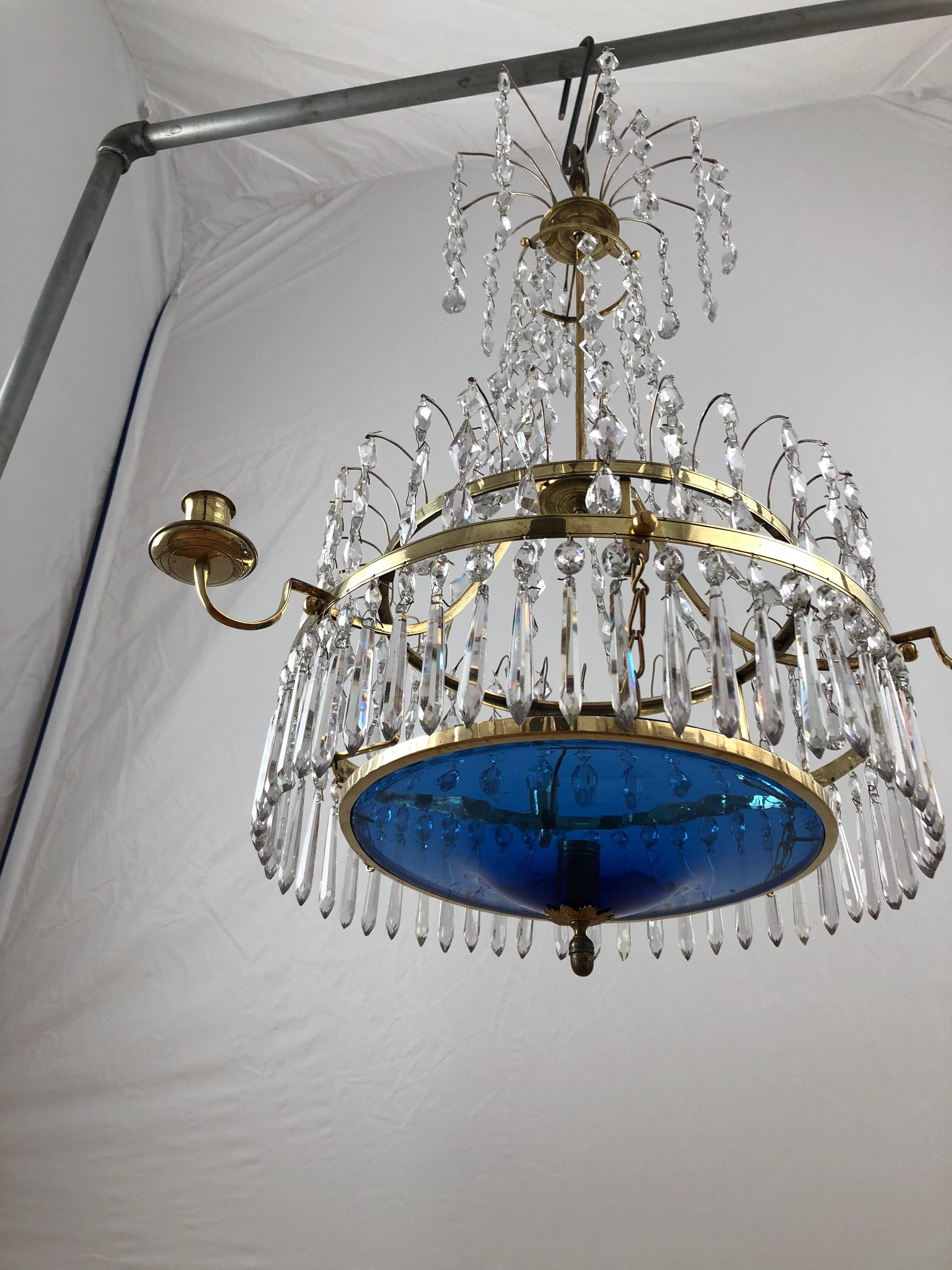 A wonderfully designed small Swedish Gustavian chandelier. With three candleholders on arms from the ring and one centrally placed on the blue glass bowl. The glass bowl is original which is rare. Most often these bowls have been broken and are