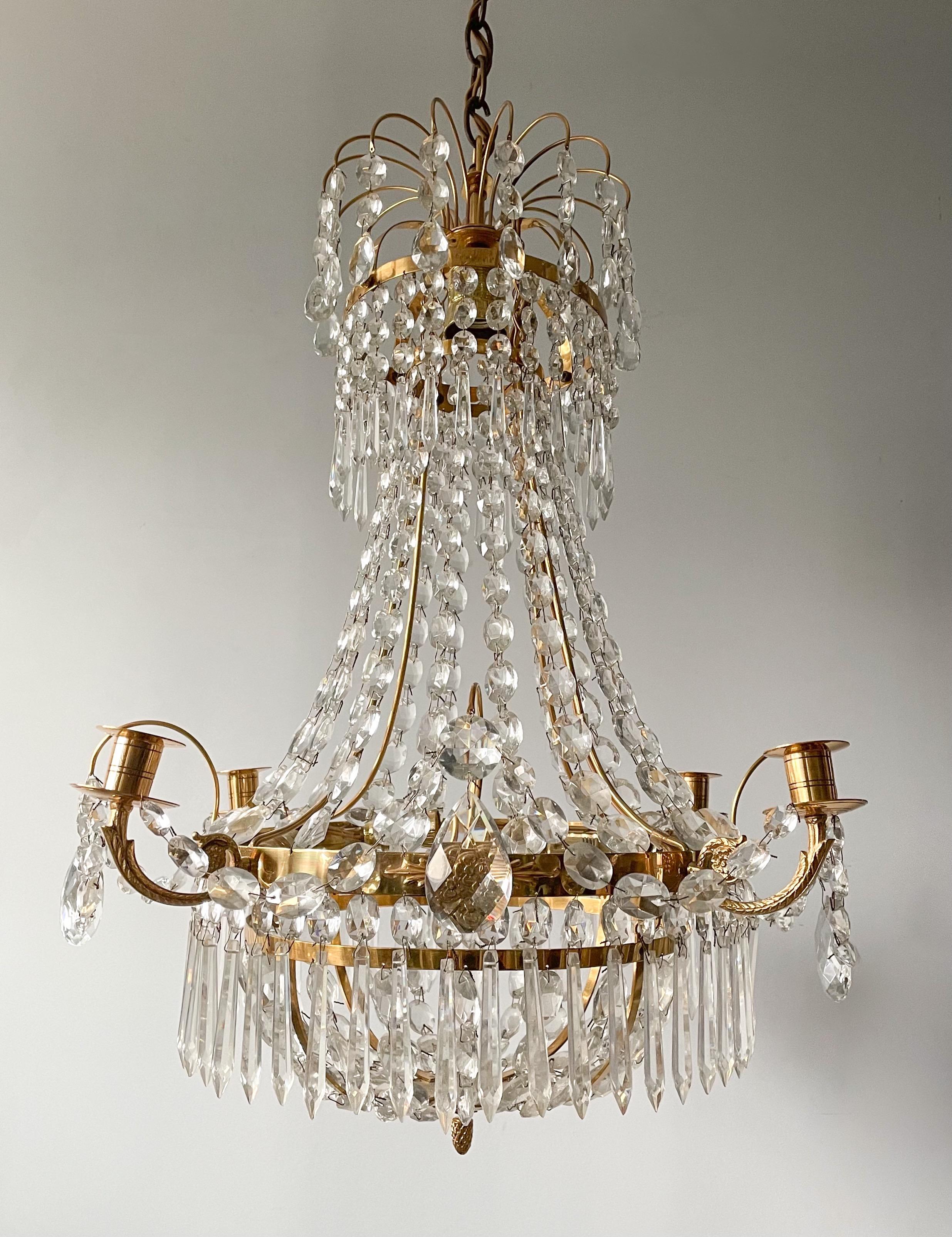 Wonderful, vintage Swedish crystal chandelier in the Gustavian style. 

The chandelier consists of a polished brass frame decorated with crystal beads and prisms in a variety of shapes. 

The chandelier is wired for electricity, there are 5