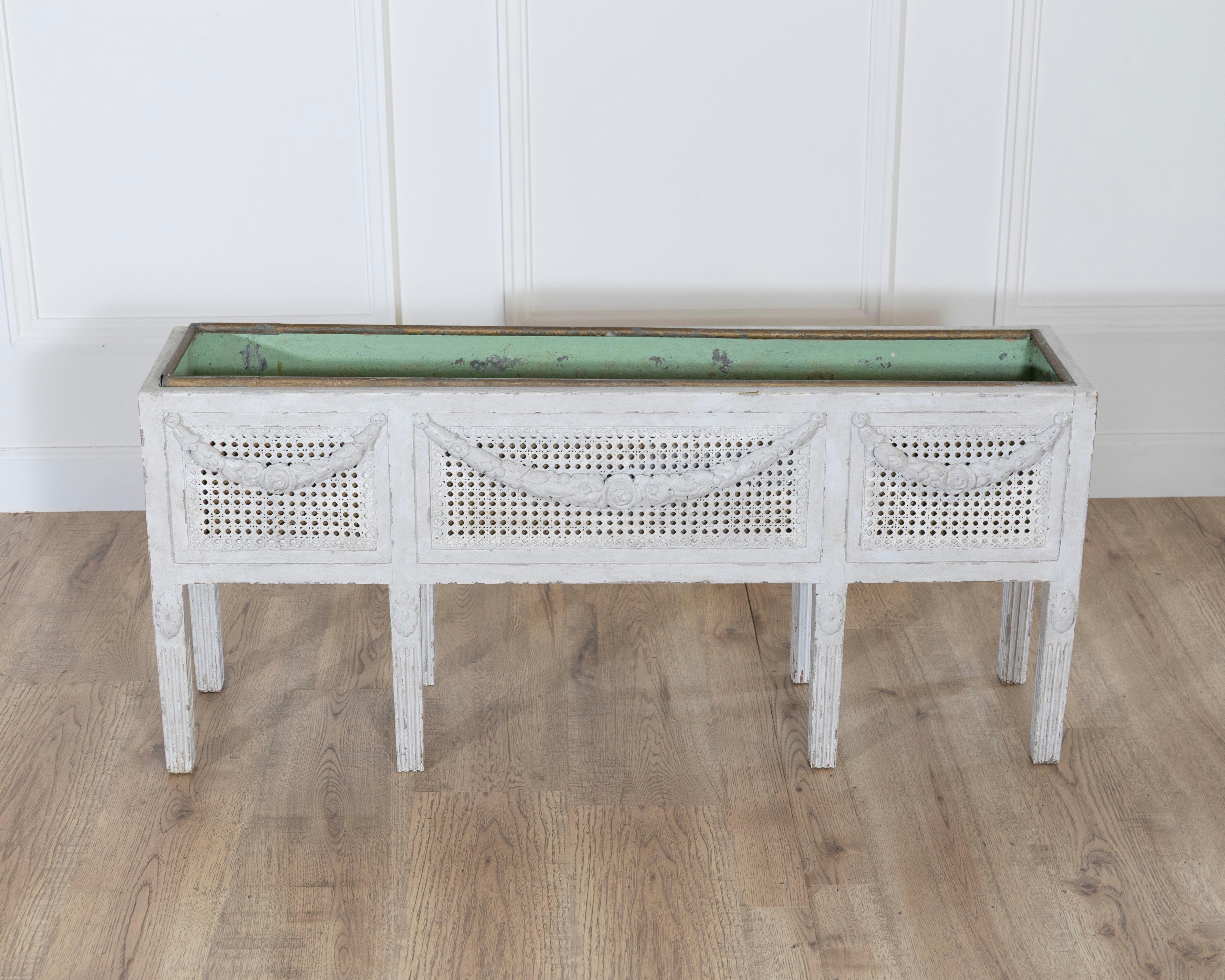 Exceptional Swedish flower trough in the Gustavian style, circa 1900, featuring original zinc liner and finely carved neoclassical details. The rectangular form rests on tapered, fluted legs and is adorned with hand-carved swags and rosettes along