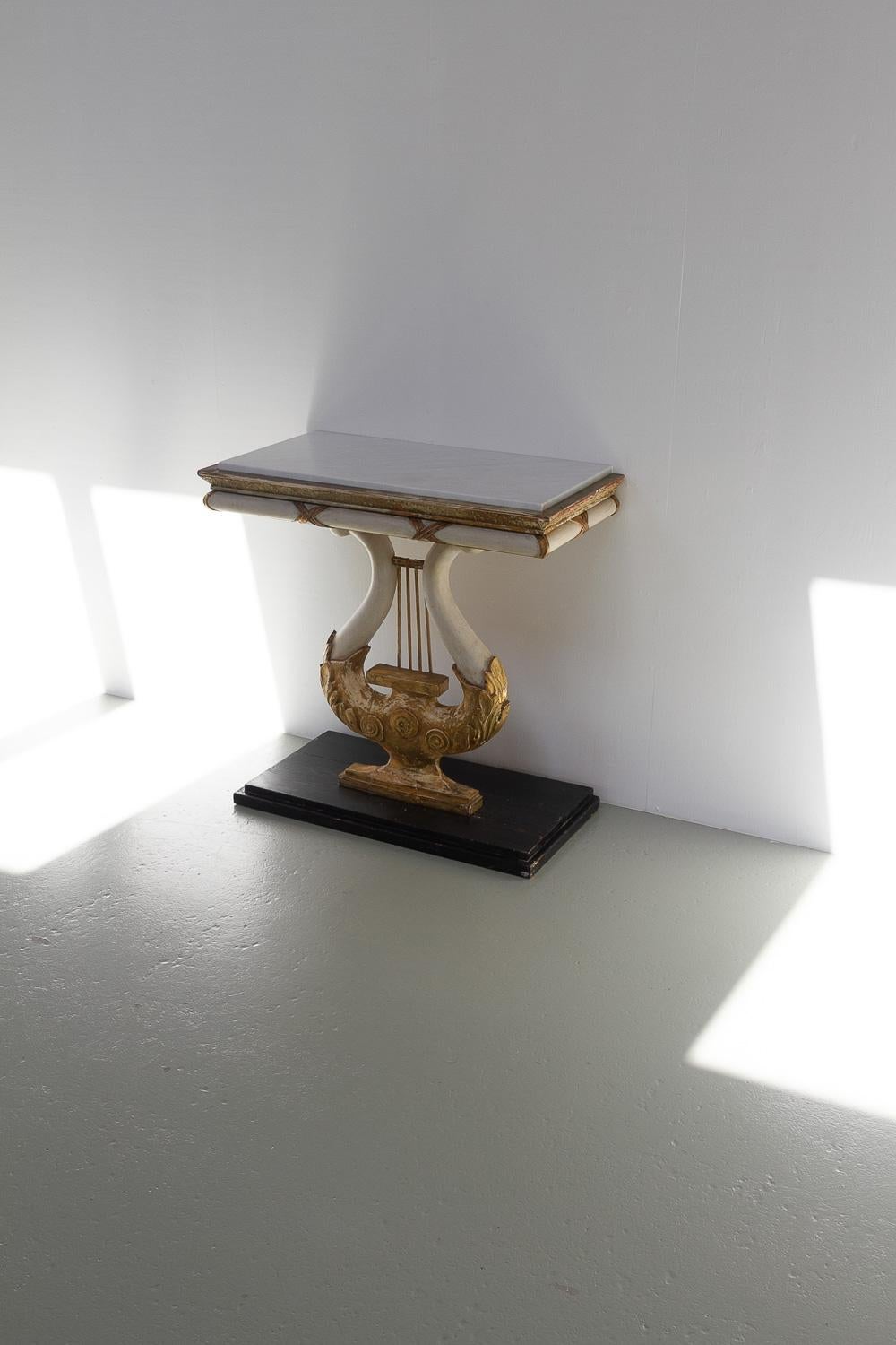 Swedish Gustavian Giltwood Console Table with Lyre and Marble Top, 1800s.

Exceptional Scandinavian late gustavian console table manufactured in Sweden between 1790 and 1820 by a master carpenter. 
White and gilded lyre-shaped column on a ebonized