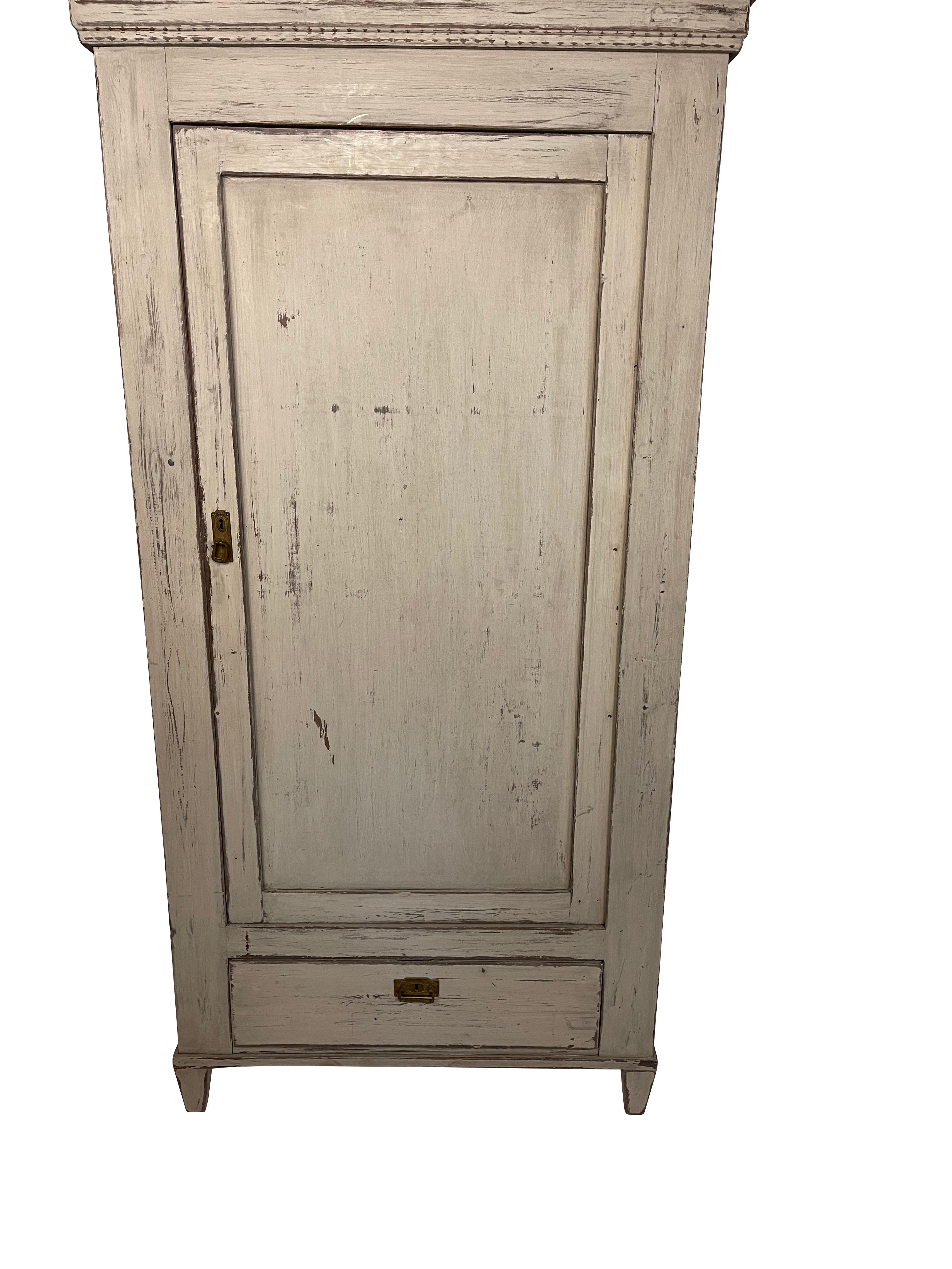 Gustavian grey painted armoire imported with one draw below and peaked cornice. Original lock and key. Possible for interior shelves.
Measures: 72.5