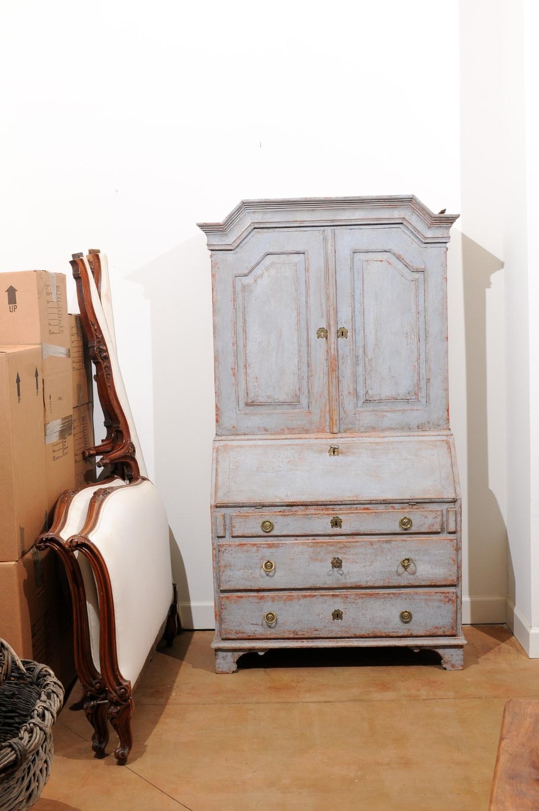 A Swedish Gustavian period tall secretary from the late 18th century, with distressed painted finish, two doors and slanted desk. Created in Sweden during the last years of the 18th century, this tall secretary features a molded cornice sitting