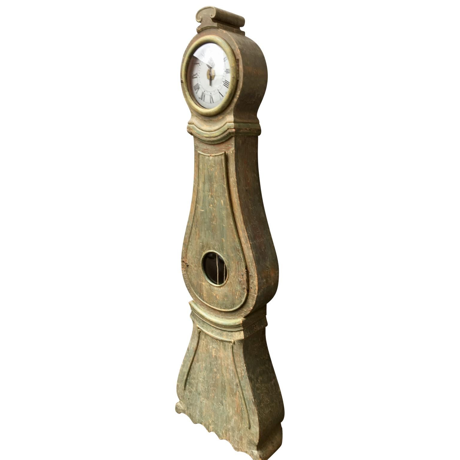 A Swedish Gustavian Grandfather clock in its original paint. The clock has being carefully scraped to his original color. It is all hand carved from the country Gustavian period of the turning of the century 1800. The face of the clockwork is of an