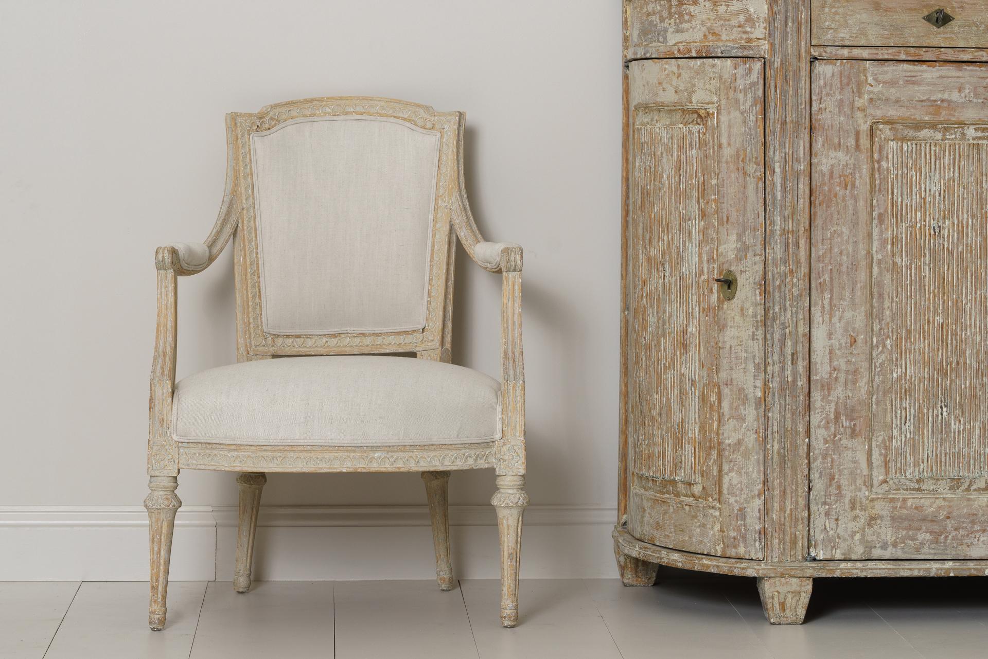 A Swedish period Gustavian armchair signed IEH by Erik Höglander (1750-1813) from Stockholm. This beautifully made chair has been hand-scraped to reveal the original paint and has been newly upholstered in linen. The seat height is 16.57 inches.