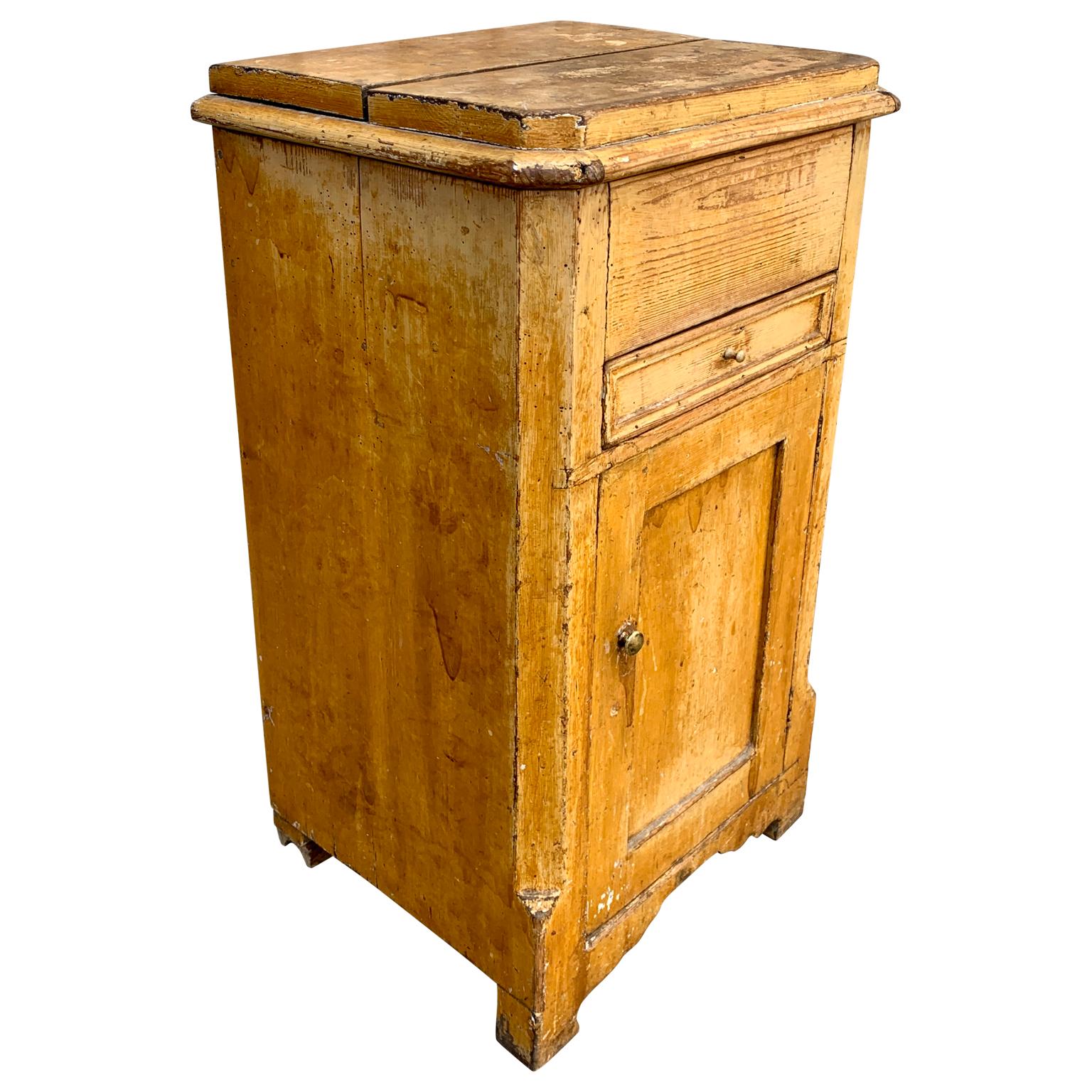 An early 19th century yellow original painted Swedish nightstand or side table with one drawer, liftable top and a door in the front. This Gustavian rural furniture's keeps totally the original paint, patina and the charming worn condition due to