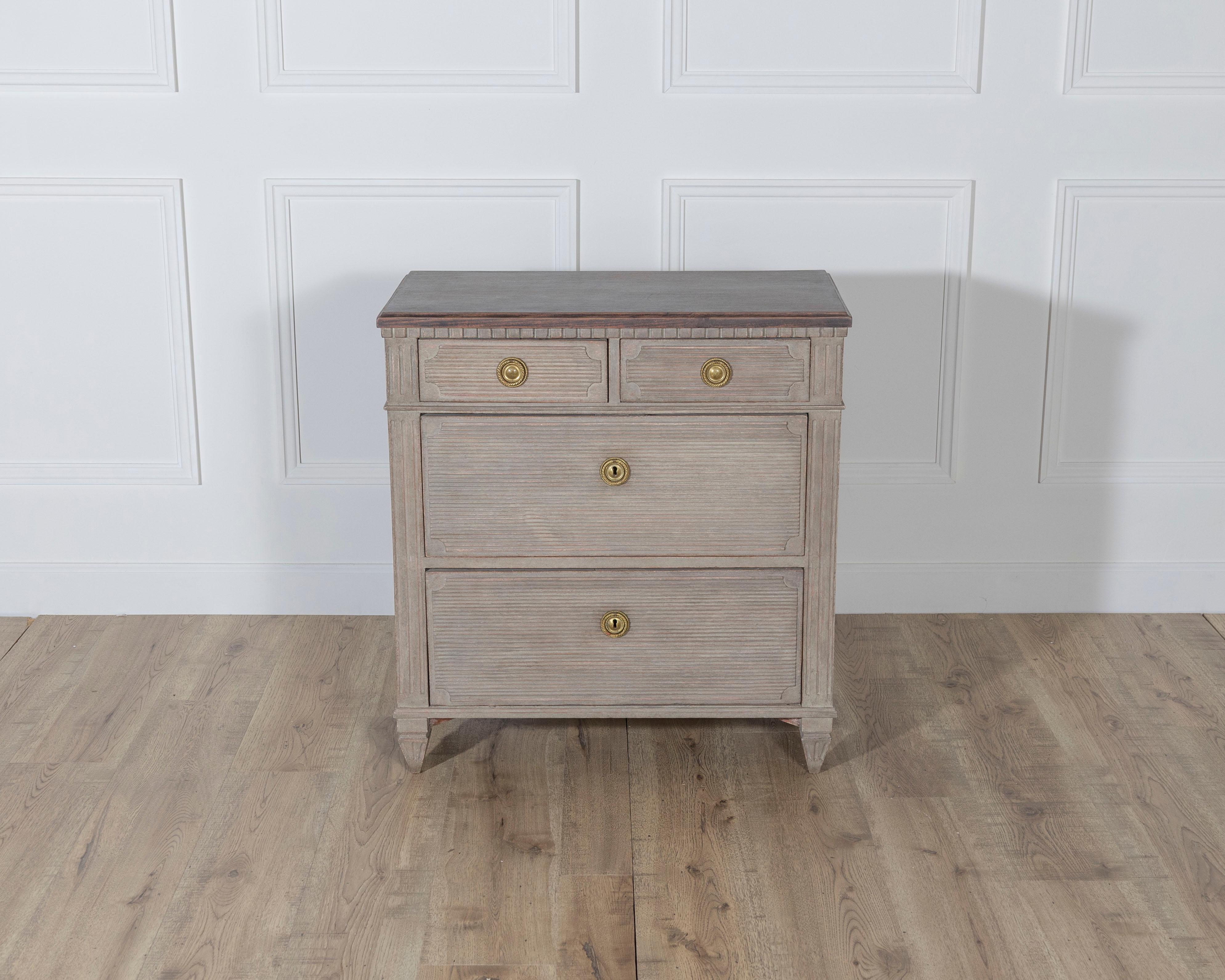 A refined Gustavian-style chest of drawers from Sweden, crafted in pine and painted in warm contrasting tones. The rectangular top, finished in a deep brown, rests above a body in soft warm gray, a palette that enhances the understated elegance of