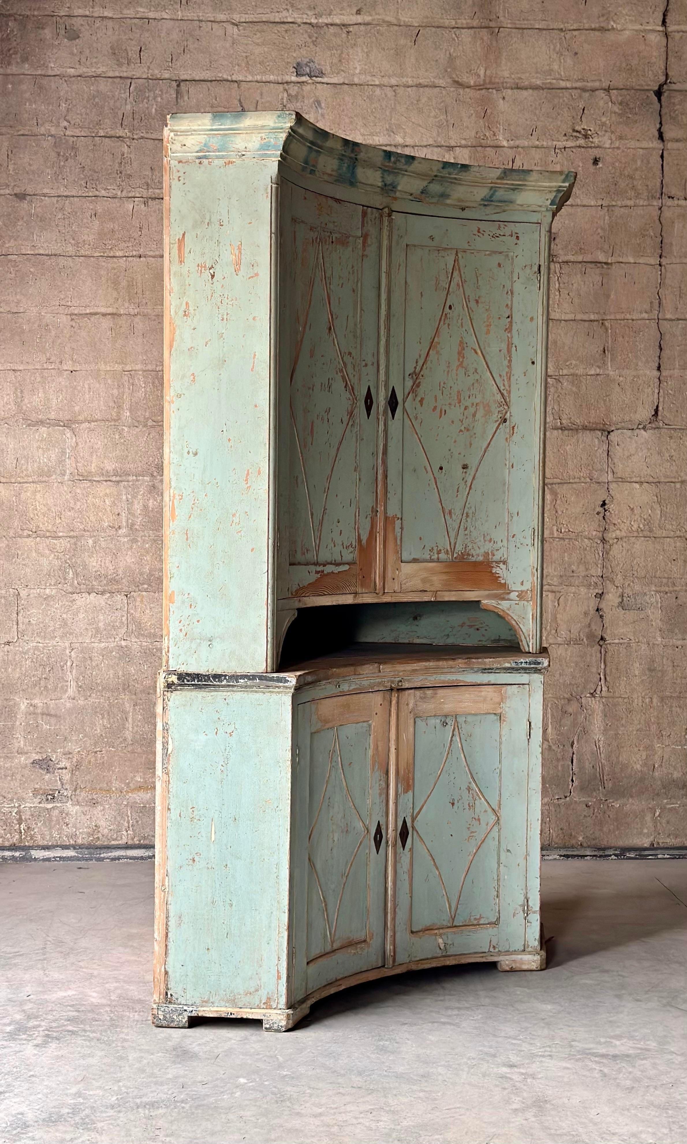Great age to this Swedish corner cabinet. Uniquely concave, and painted in teal with the perfect amount of distress on diamond paneled doors.